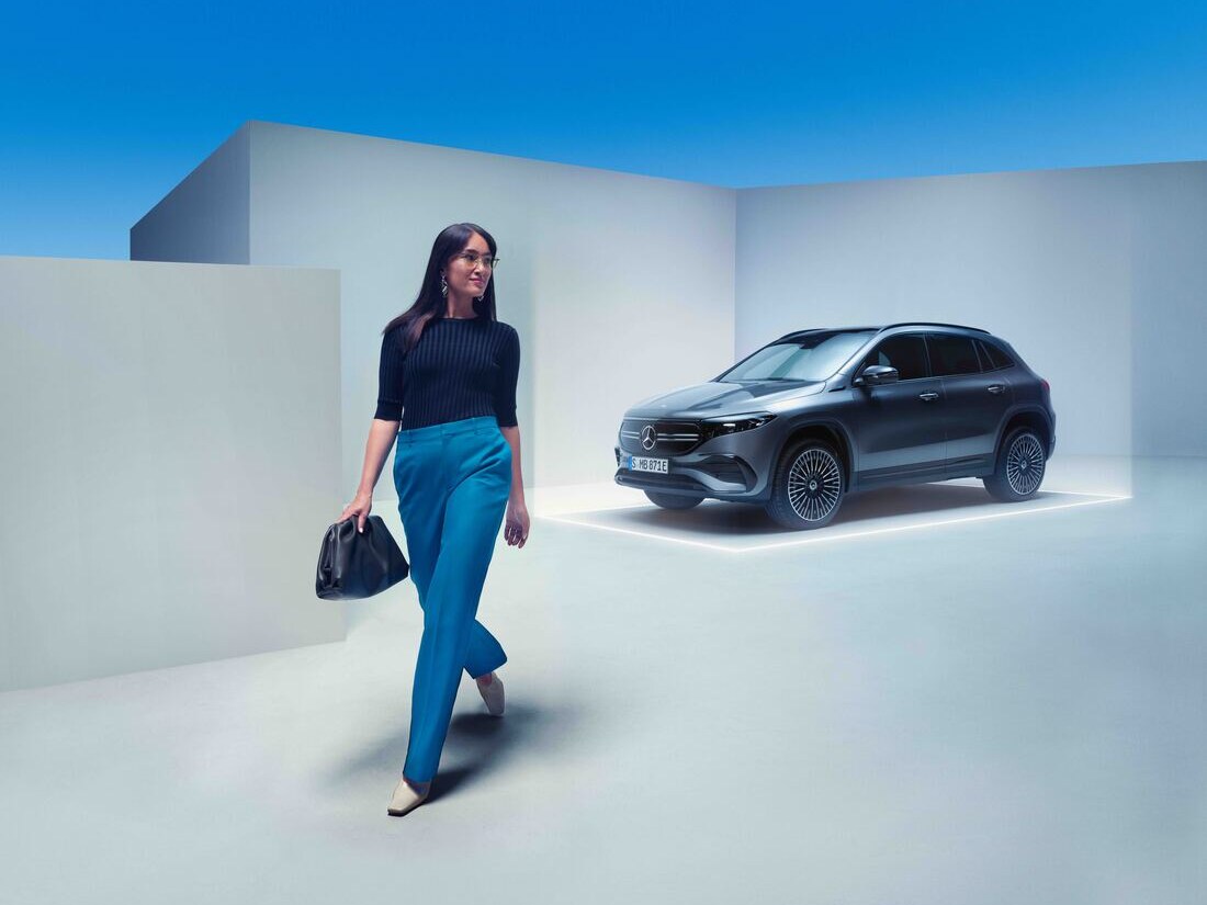 O femeie se îndepărtează de autovehiculul său Mercedes-Benz parcat.