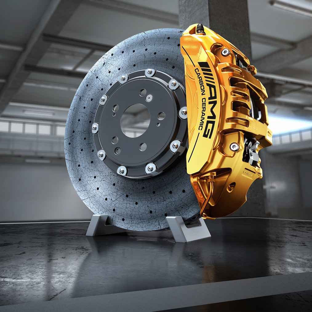 Detaliu al unui disc de frână din compozit ceramic de performanță ridicată AMG cu un etrier de frână vopsit în galben.