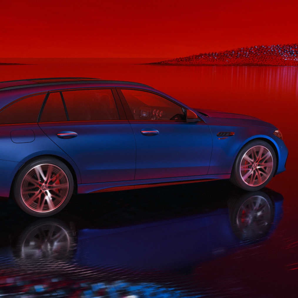 Mercedes-AMG C 63 S E PERFORMANCE model T vopsit în MANUFAKTUR albastru spectral magno, perspectivă laterală pe un fundal roșu.