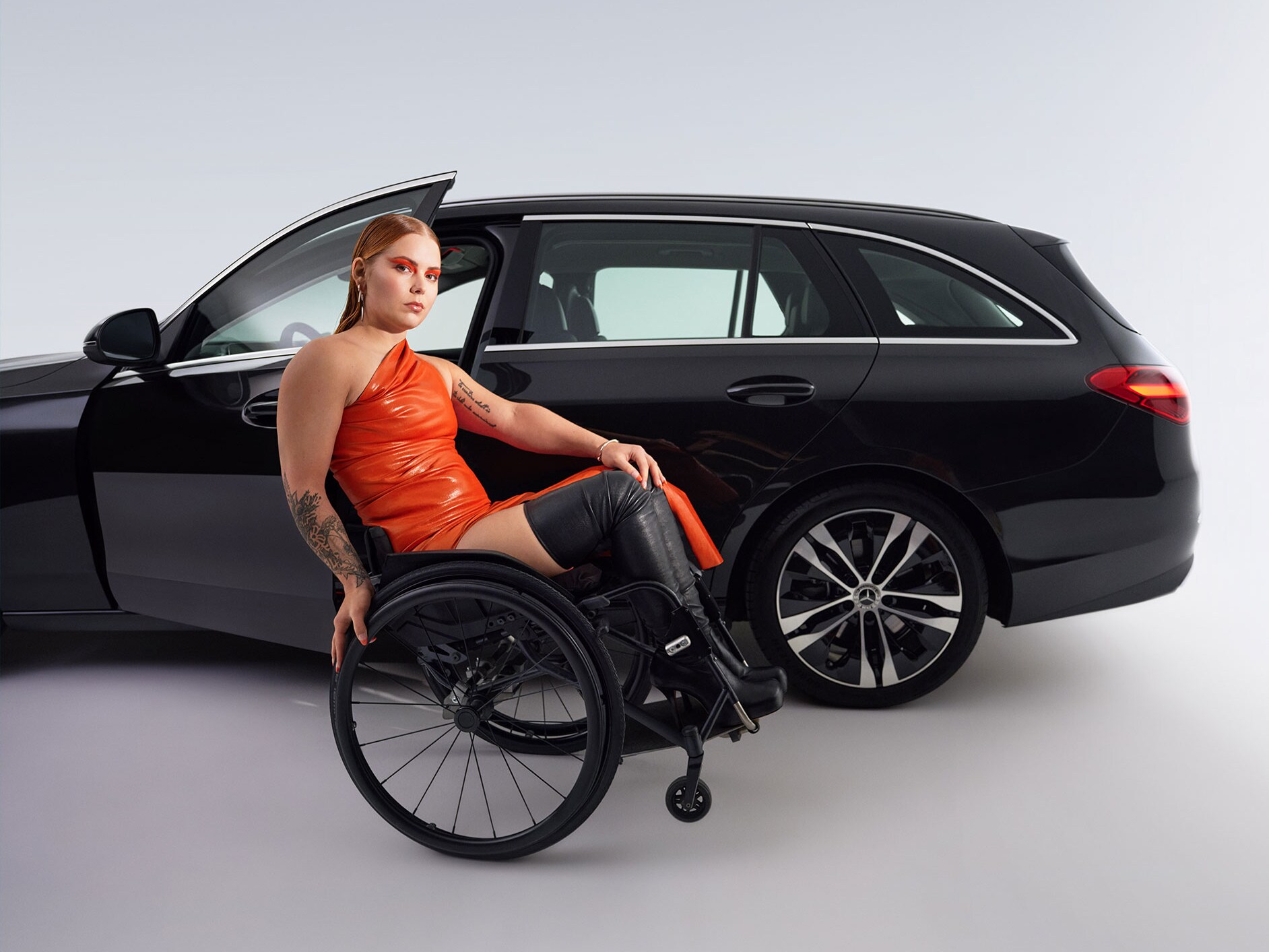 Modelul Clasa C model T transformat pentru persoanele cu dizabilități dintr-o vedere laterală și o femeie în scaunul cu rotile.