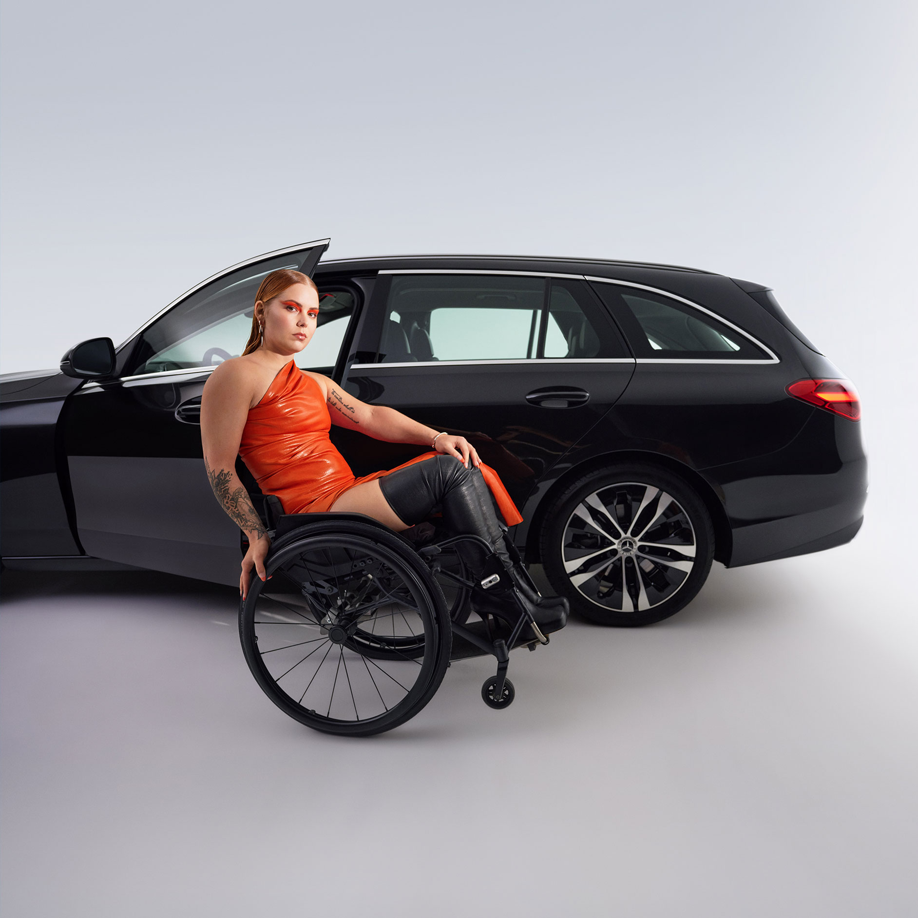 Sisteme de asistare la urcarea și coborârea din autovehicul | Sisteme de asistență la rulare | Mercedes-Benz Modelul Clasa C model T transformat pentru persoanele cu dizabilități dintr-o vedere laterală și o femeie în scaunul cu rotile.