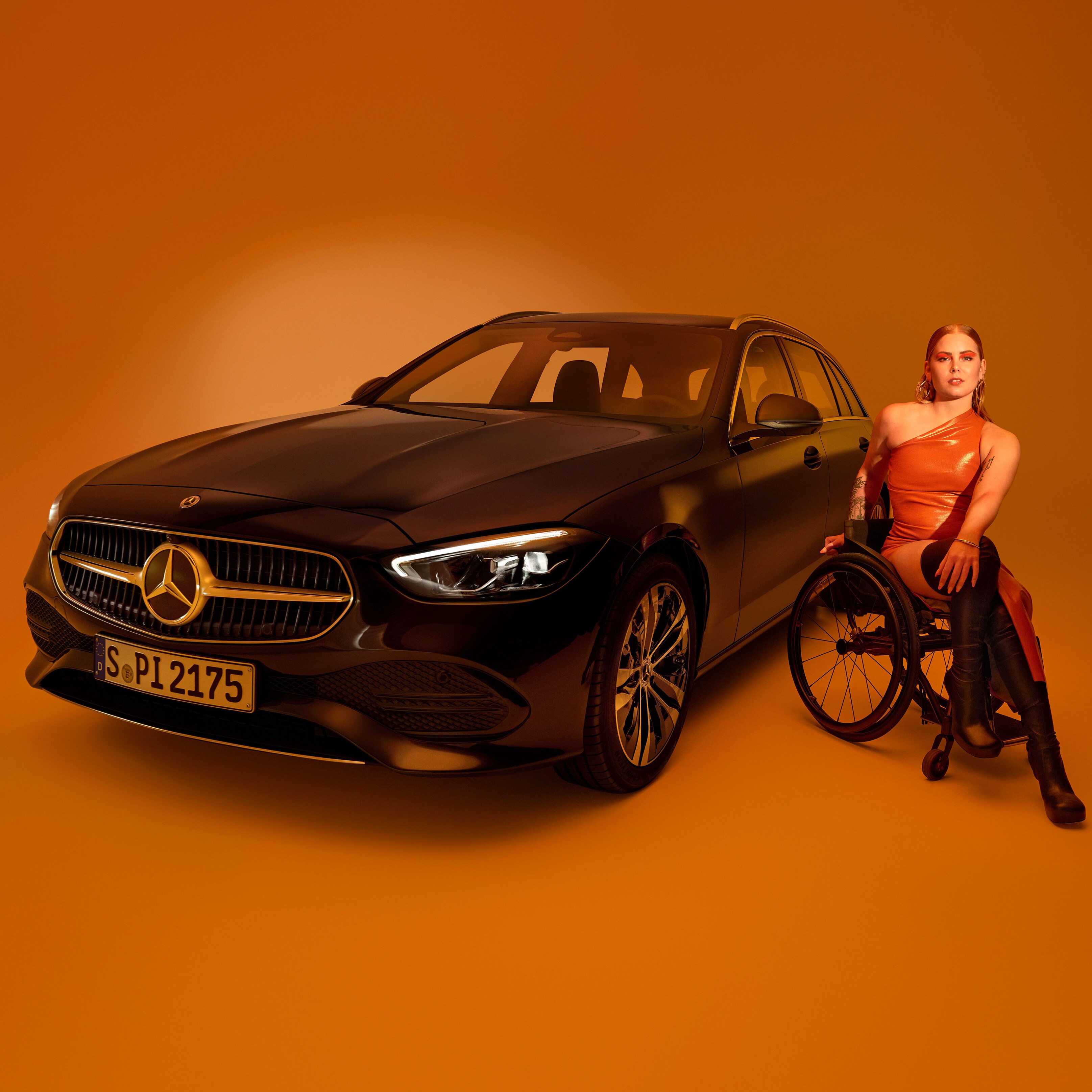 Exteriorul unui model Clasa C model T transformat într-un autovehicul adaptat persoanelor cu dizabilități și o femeie în scaun cu rotile.