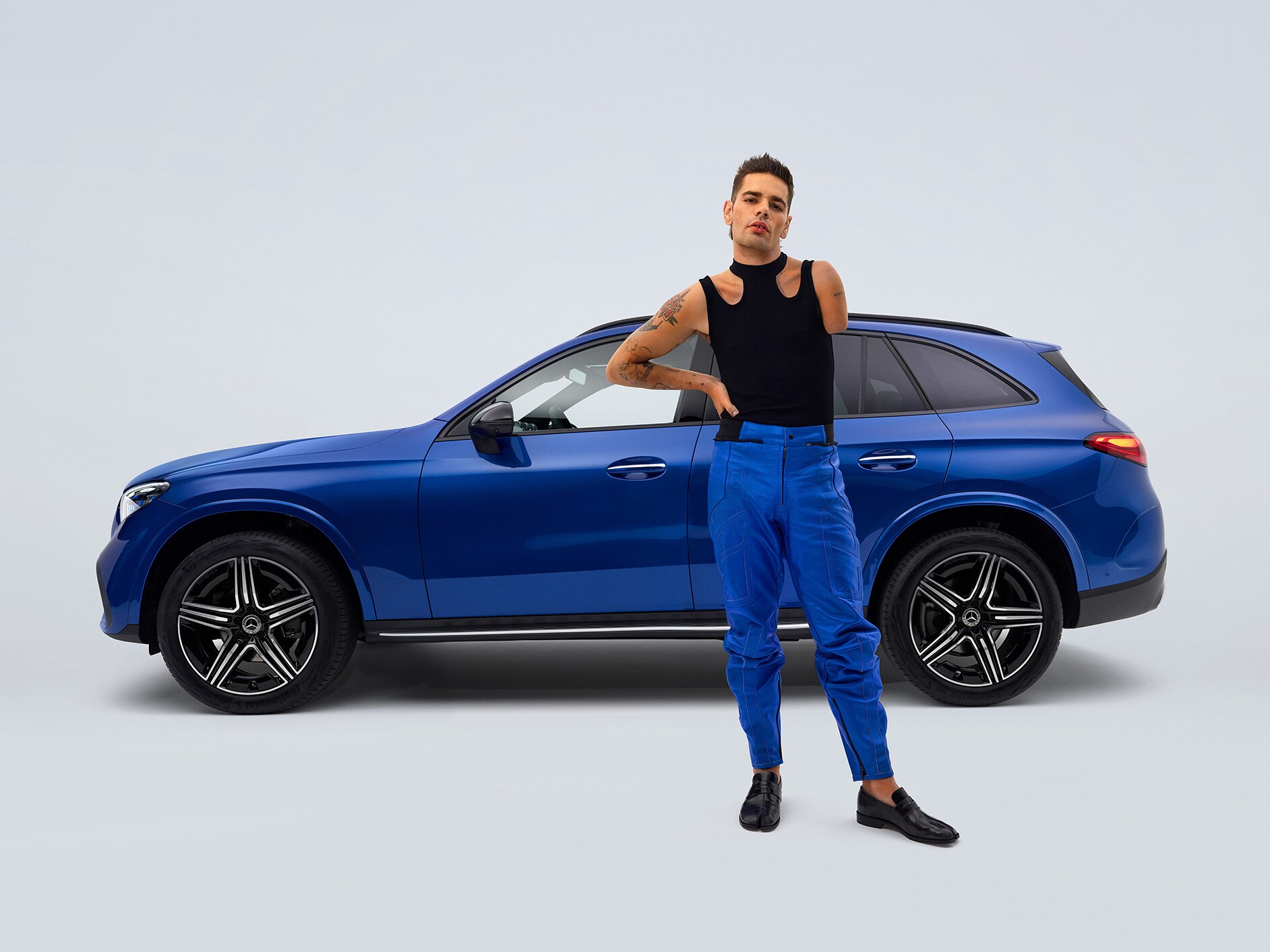 Modelul Mercedes-Benz GLC SUV transformat pentru persoanele cu dizabilități într-o vedere laterală și un bărbat cu proteză de picior în prim-plan.