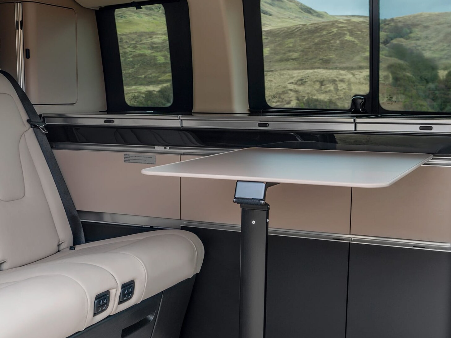 Interiorul modelului Mercedes-Benz Marco Polo cu masă pliabilă și spațiu de locuit flexibil.