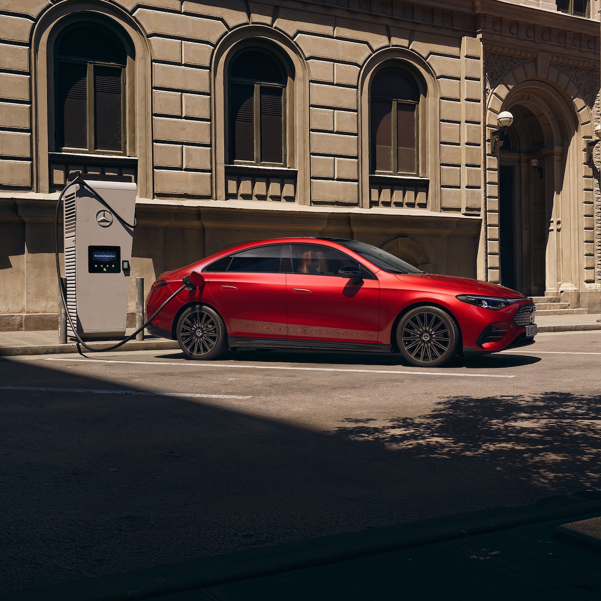 Perspectivă laterală a modelului Mercedes-Benz CLA C174 la o stație de încărcare.