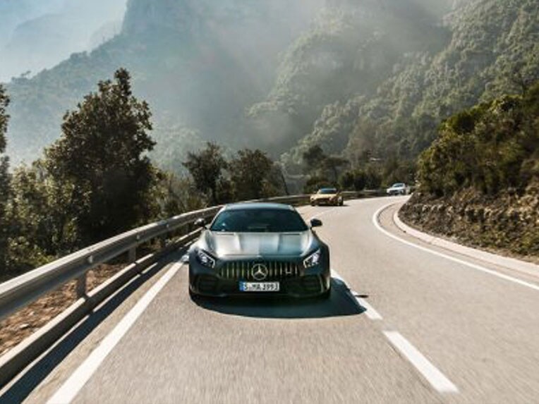 Un model Mercedes-AMG GT R în perspectivă frontală, deplasându-se pe o stradă.