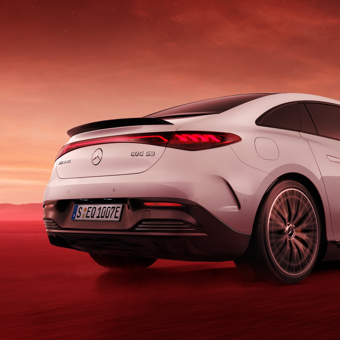 Perspectivă din spate a unui model Mercedes-AMG EQE 53 4MATIC+ cu imagine detaliată a capacului hayon și spoilerului, văzute de dedesubt.