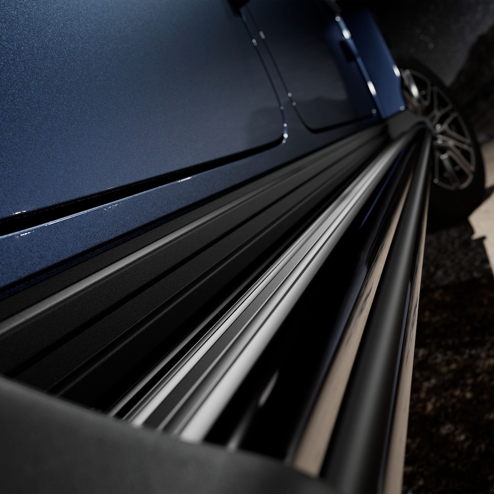 Perspectivă laterală spate (de sus) a unui model Mercedes-Benz G 450 d cu trepte de acces MANUFAKTUR în negru.
