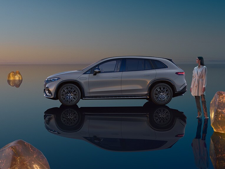 Modelul complet electric EQS SUV de la Mercedes-Benz staționând în universul său EQS-SUV, cu podea reflectantă.