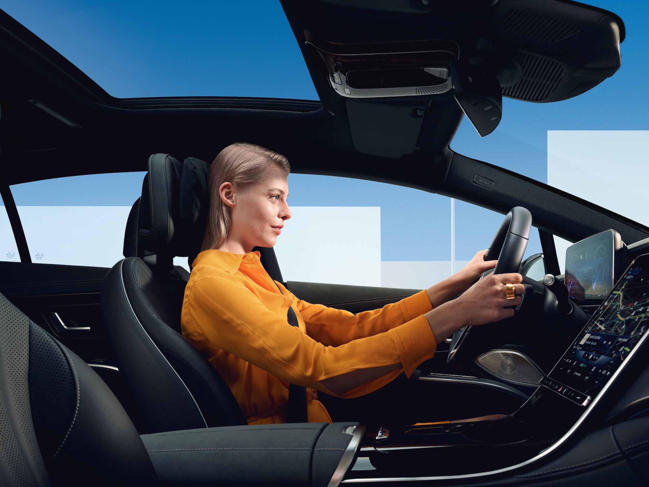 O femeie stă într-un Mercedes Benz.