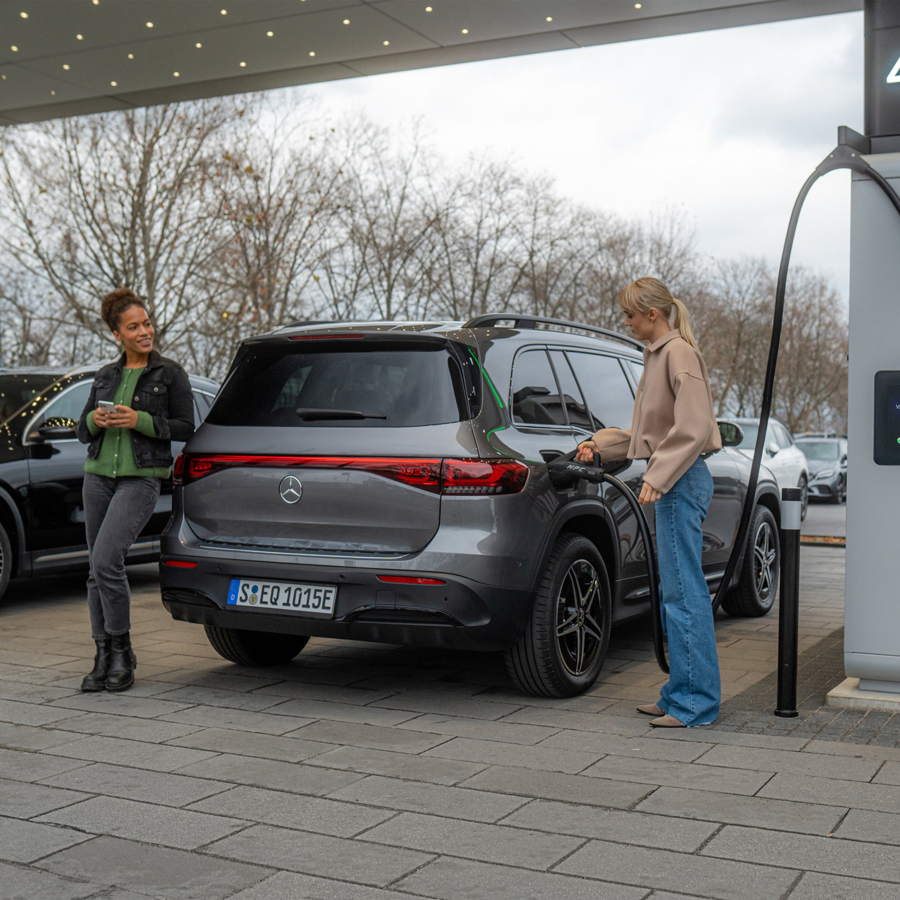 Două autovehicule electrice Mercedes-Benz la o stație de încărcare.