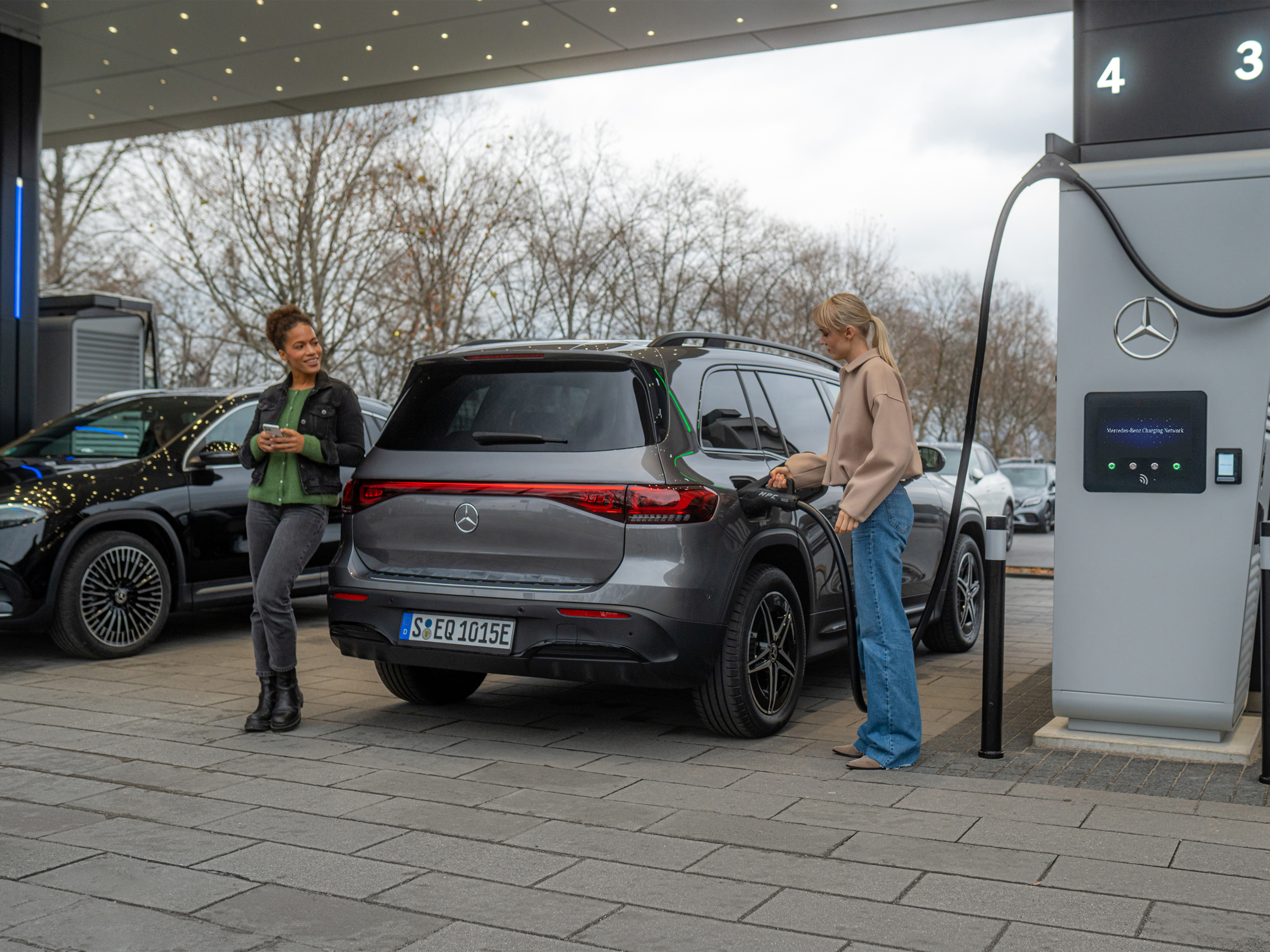 Rețea de încărcare Mercedes-Benz | Încărcare pe drum | Mercedes-Benz Două autovehicule electrice Mercedes-Benz la o stație de încărcare.