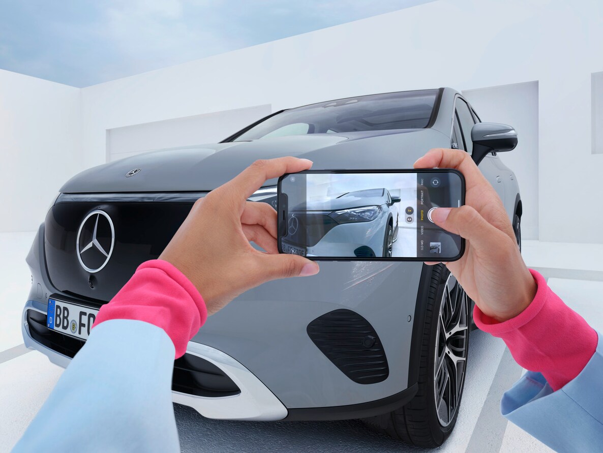 Persoană care fotografiază un Mercedes-Benz cu telefonul mobil