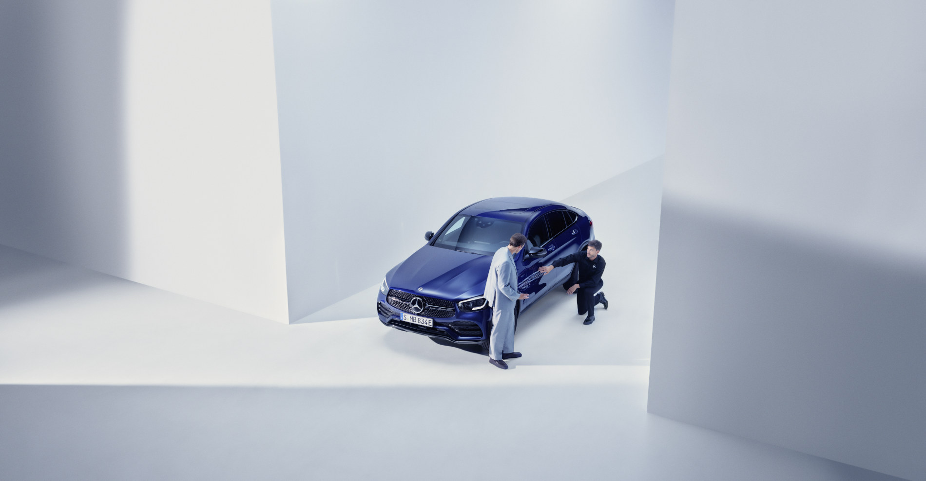 Asistență în caz de daune și defecțiune | Mercedes-Benz O femeie stă în fața autovehiculului ei Mercedes-Benz cu telefonul în mână și participă la un apel