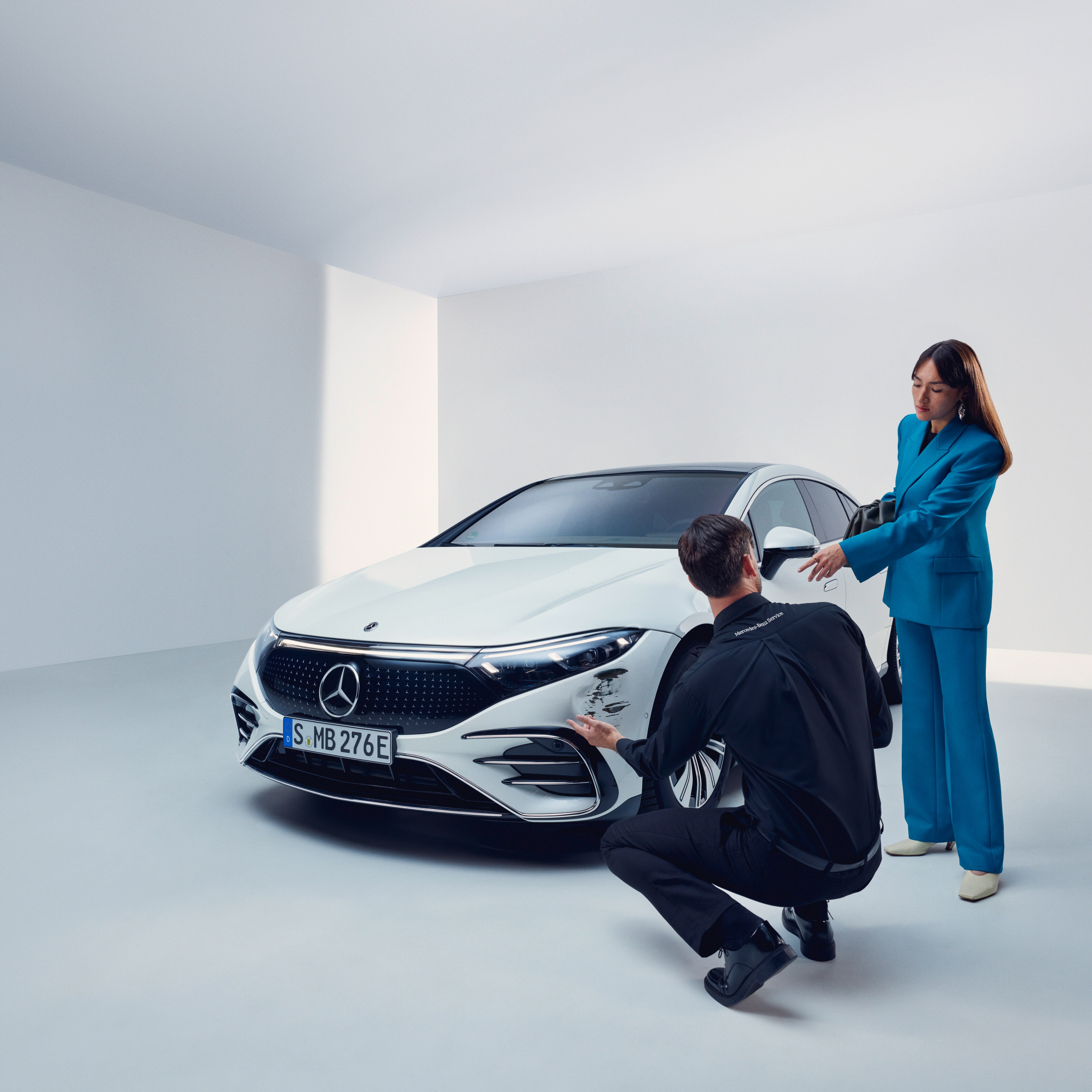 Un bărbat inspectează autovehiculul Mercedes-Benz al unei femei.