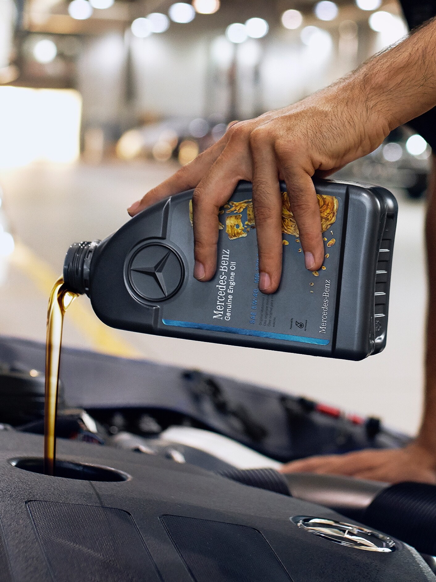 O persoană care toarnă ulei de motor într-un autovehicul Mercedes-Benz.