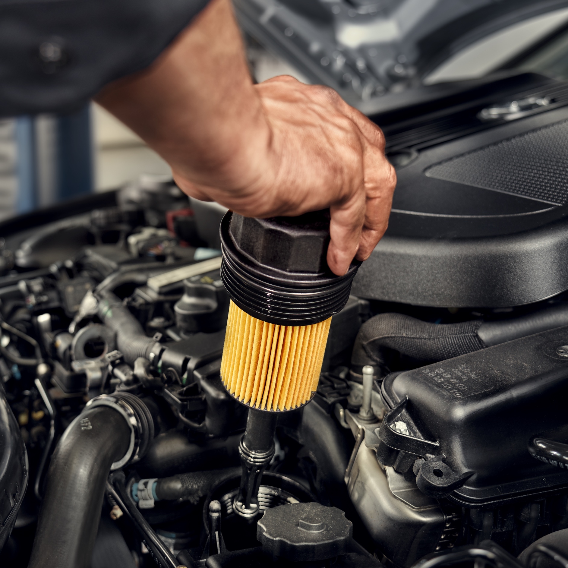 Filtru de ulei | Mercedes-Benz Un tehnician instalează filtrul de ulei în autovehiculul Mercedes-Benz.