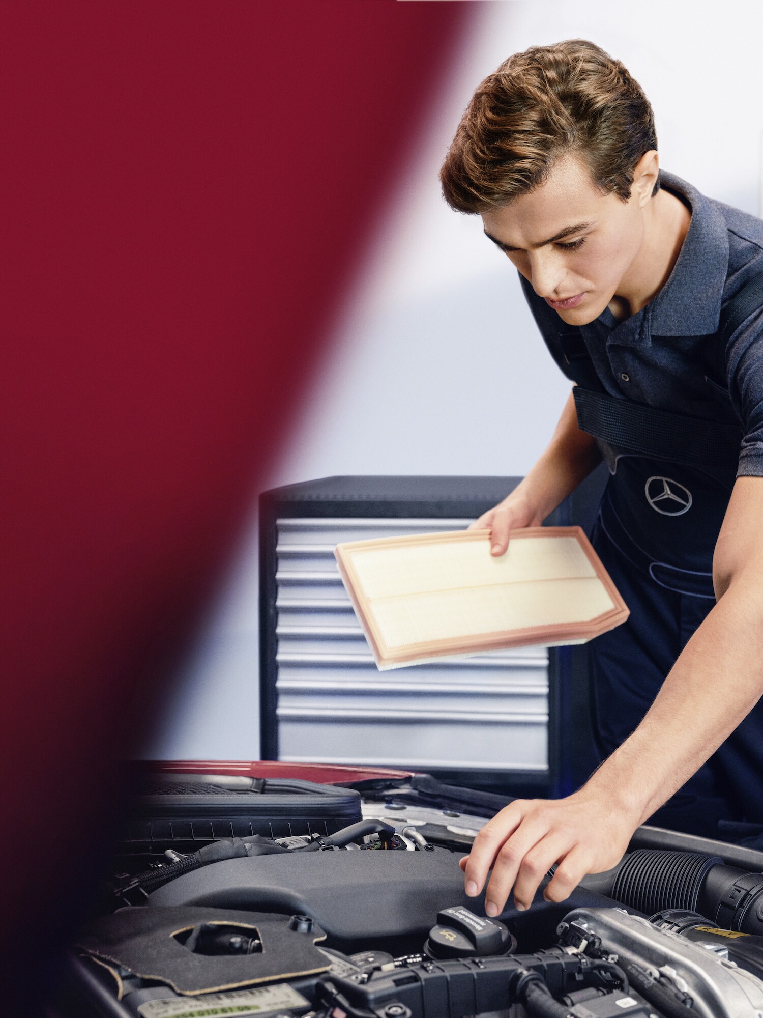 Un tehnician verifică motorul unui autovehicul Mercedes-Benz.