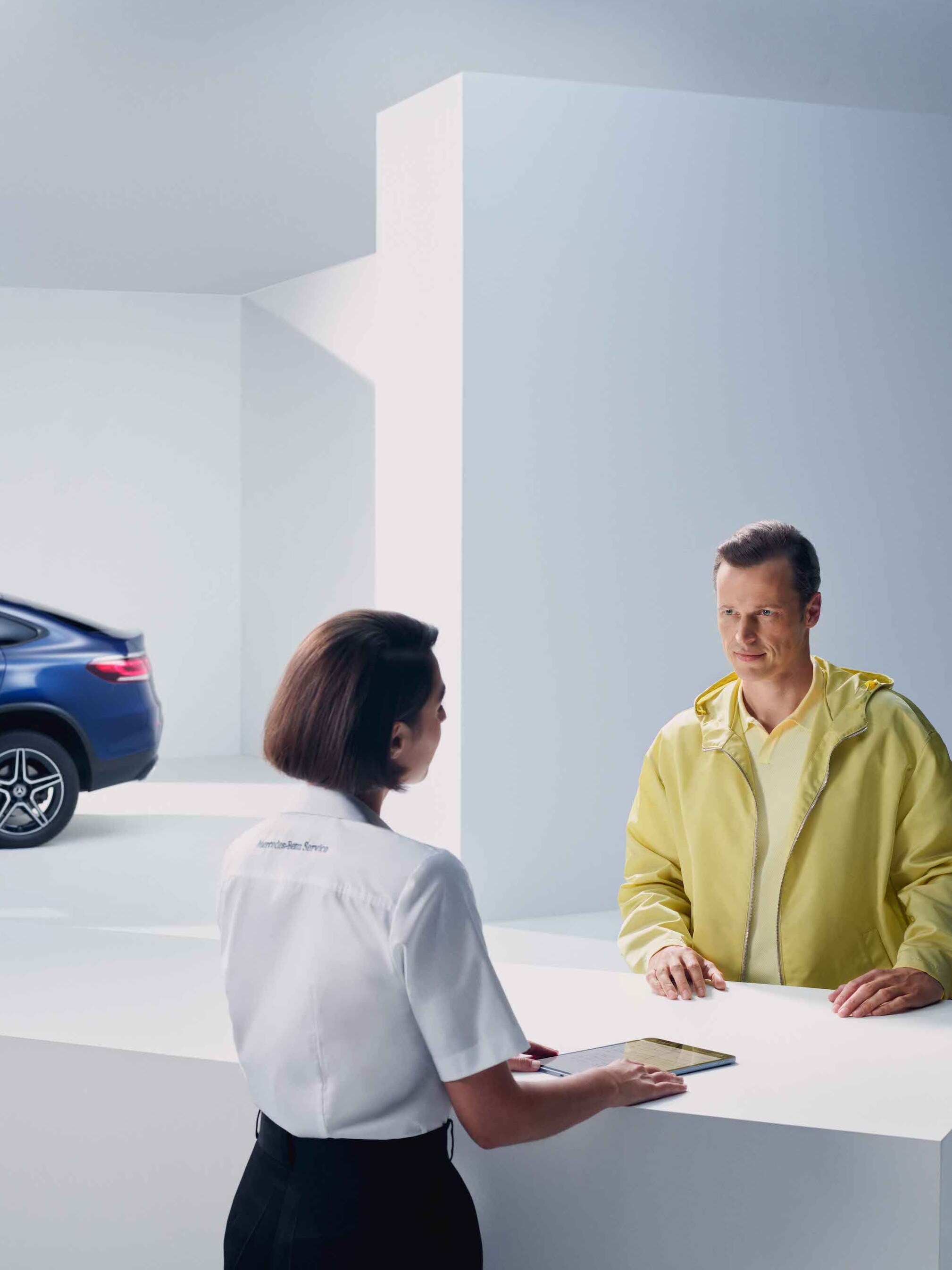 Un bărbat este sfătuit de un angajat Mercedes-Benz.