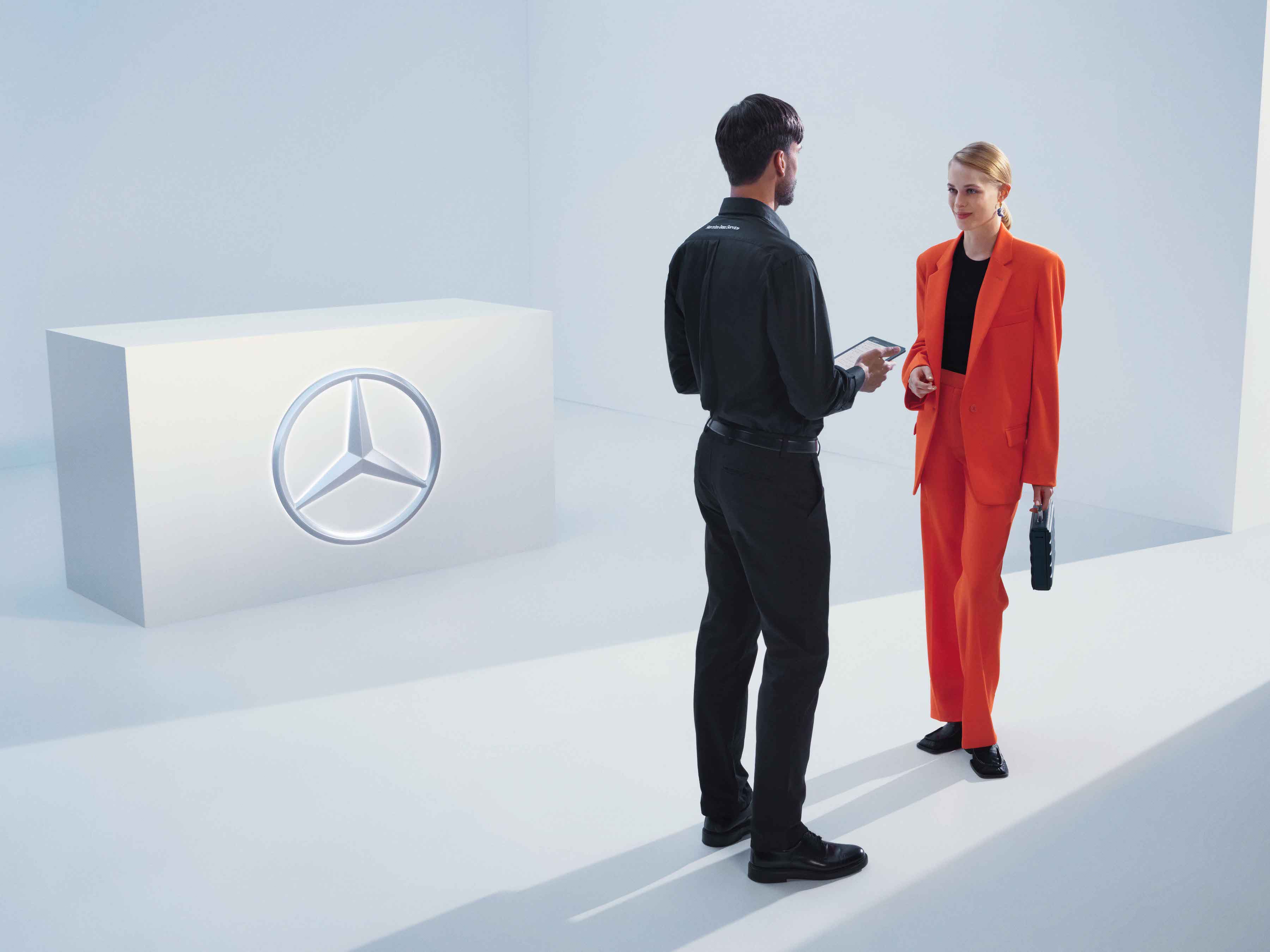Rechemări în service | Mercedes-Benz O femeie discută cu un angajat Mercedes-Benz.