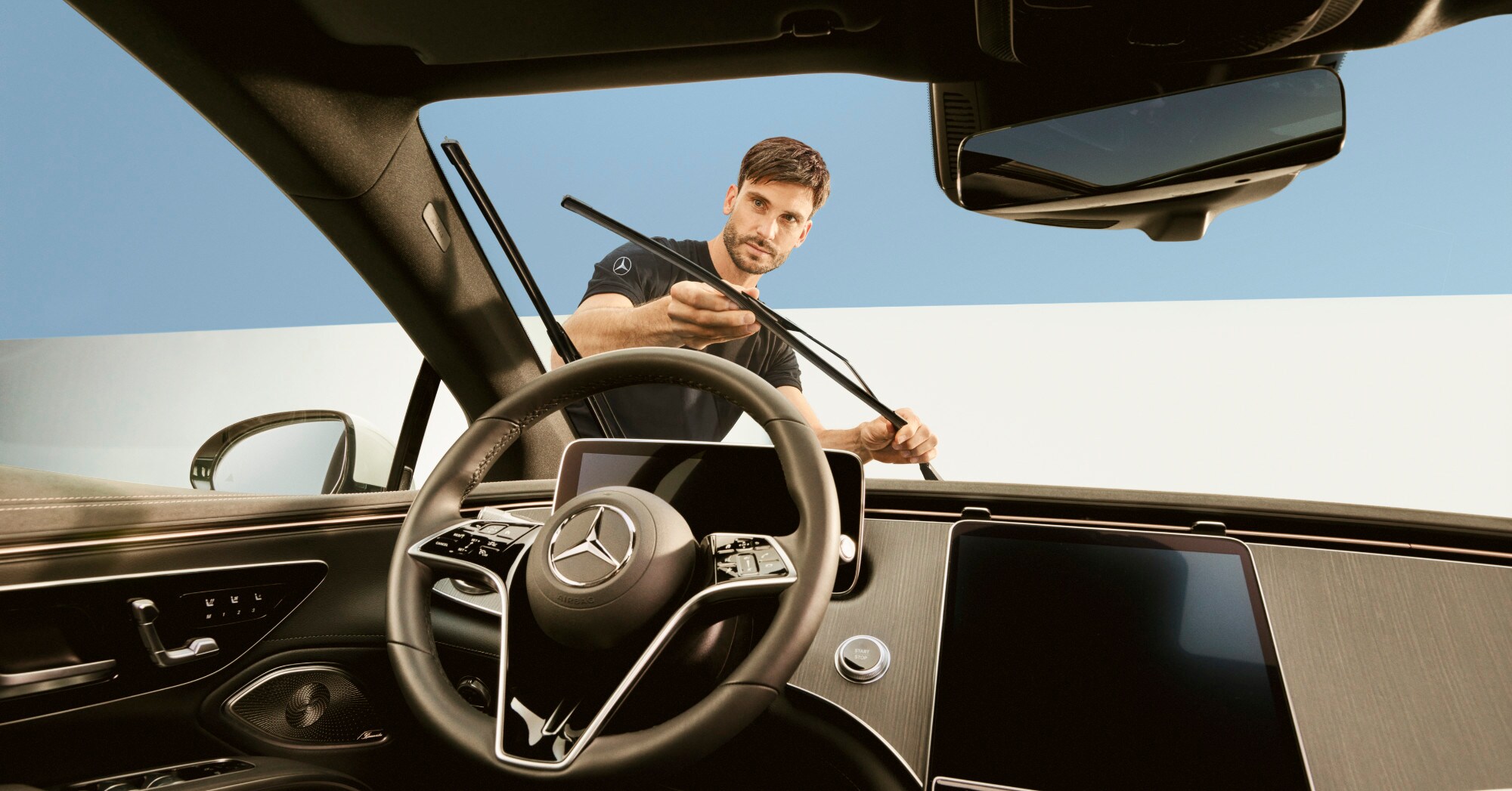Un tehnician repară lamelele ștergătoarelor unui autovehicul Mercedes-Benz.