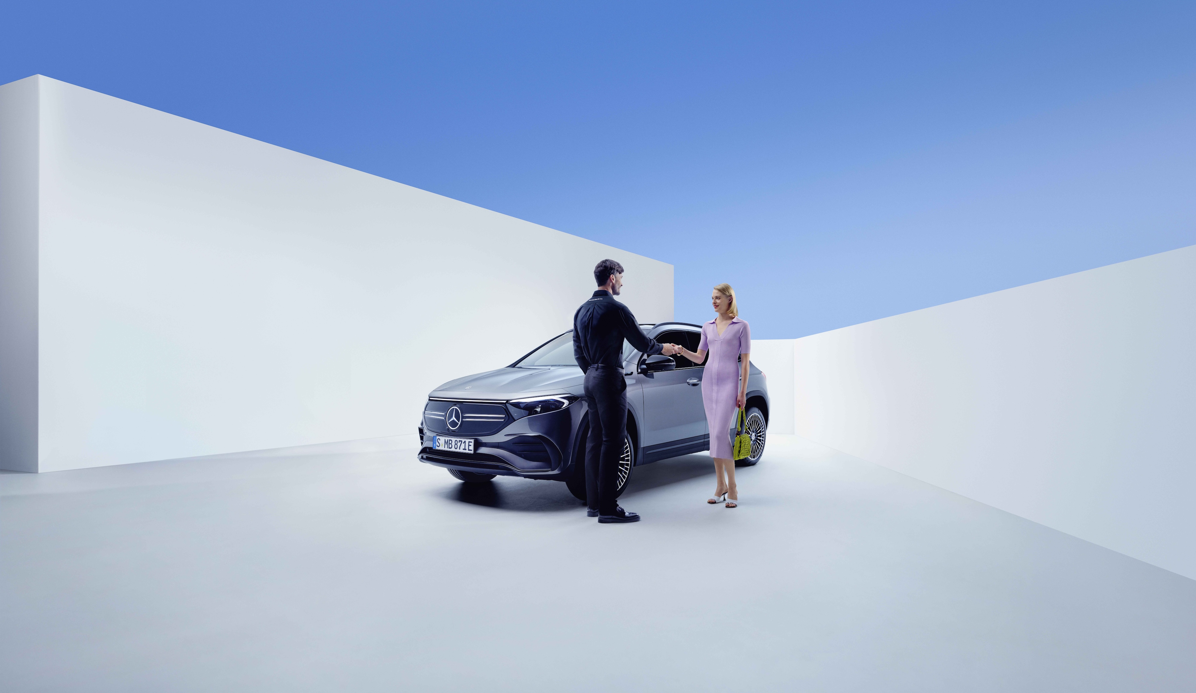 Service și reparații | Mercedes-Benz Un angajat Mercedes-Benz și o femeie își dau mâna în fața unui Mercedes-Benz