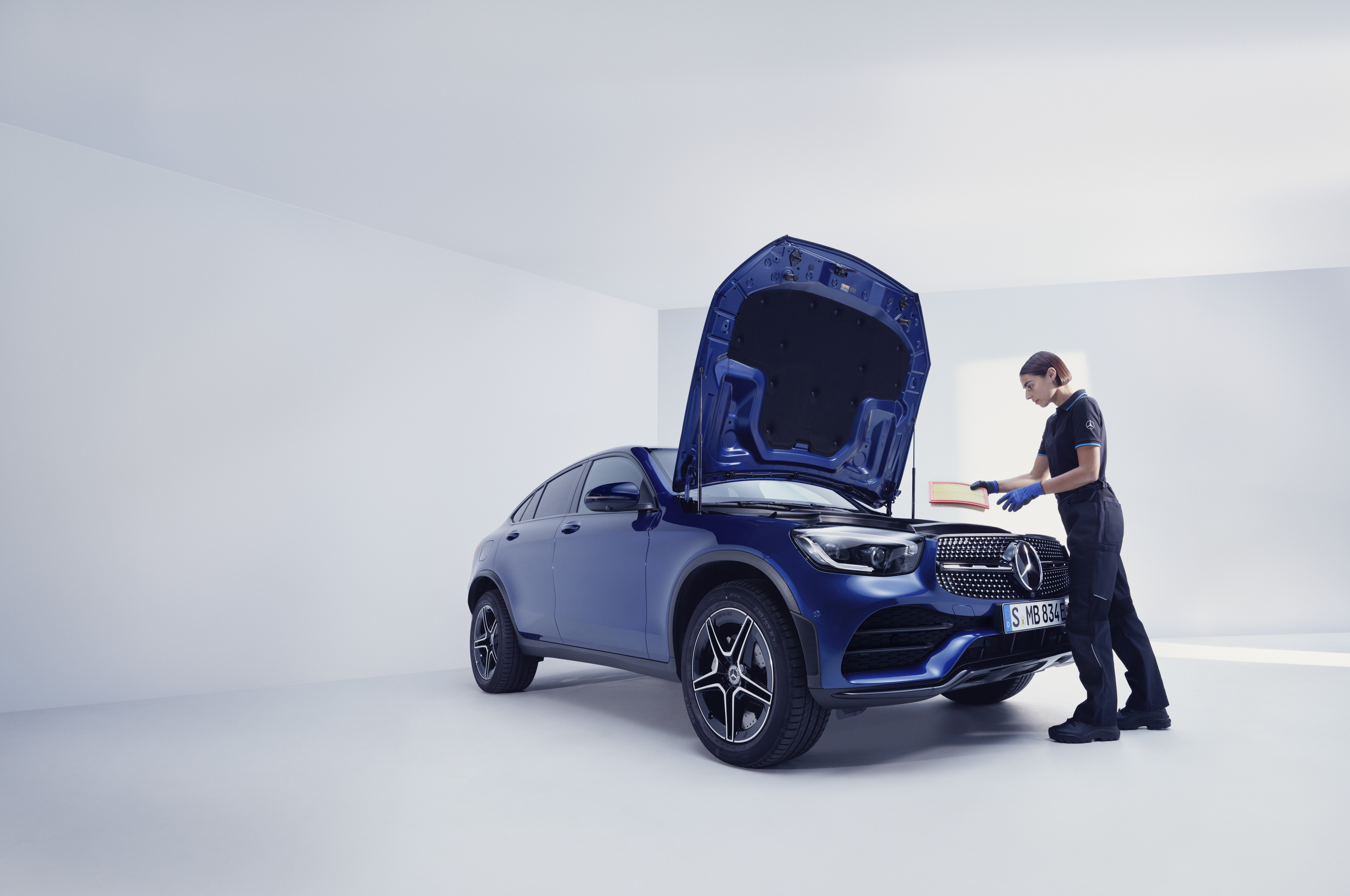 Servicii de revizie | Mercedes-Benz Un mecanic de la Mercedes-Benz examinează un Mercedes-Benz.