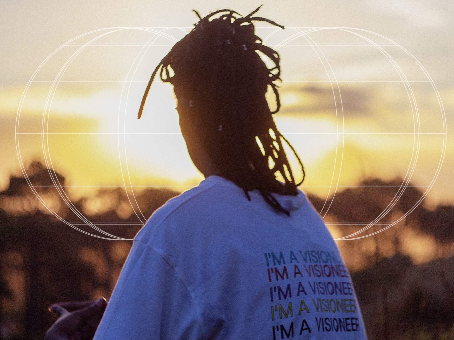 Femeie surprinsă din spate admirând apusul, purtând un tricou beVisioneers.