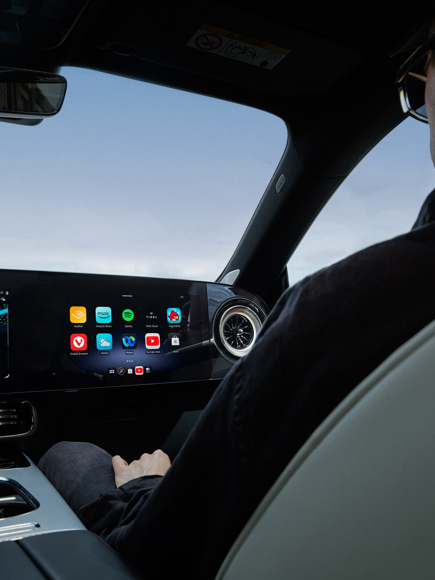 Perspectivă interioară a cockpit-ului unui model Mercedes-Benz cu sistem multimedia MBUX.