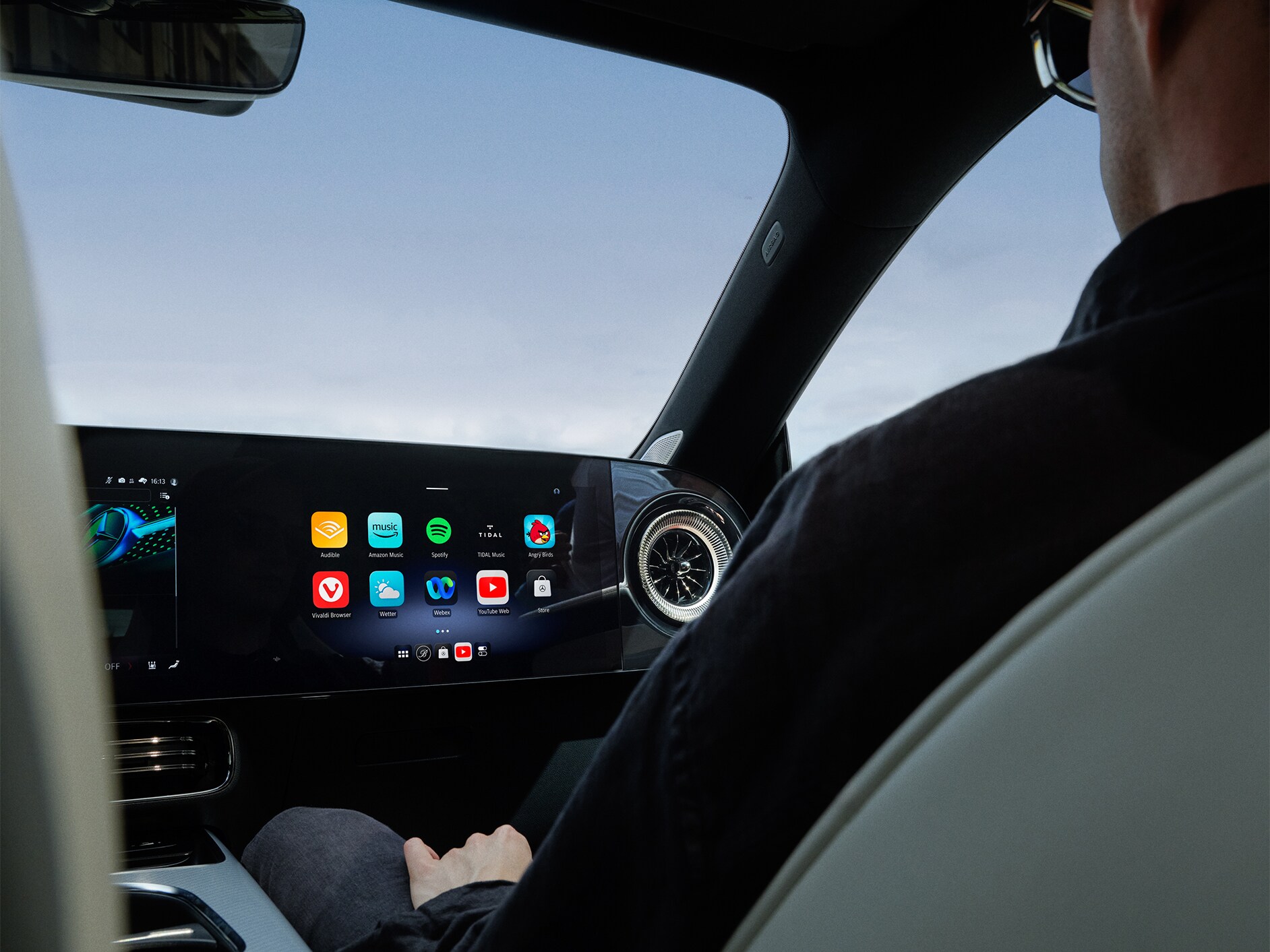 Perspectivă interioară a cockpit-ului unui model Mercedes-Benz cu sistem multimedia MBUX.