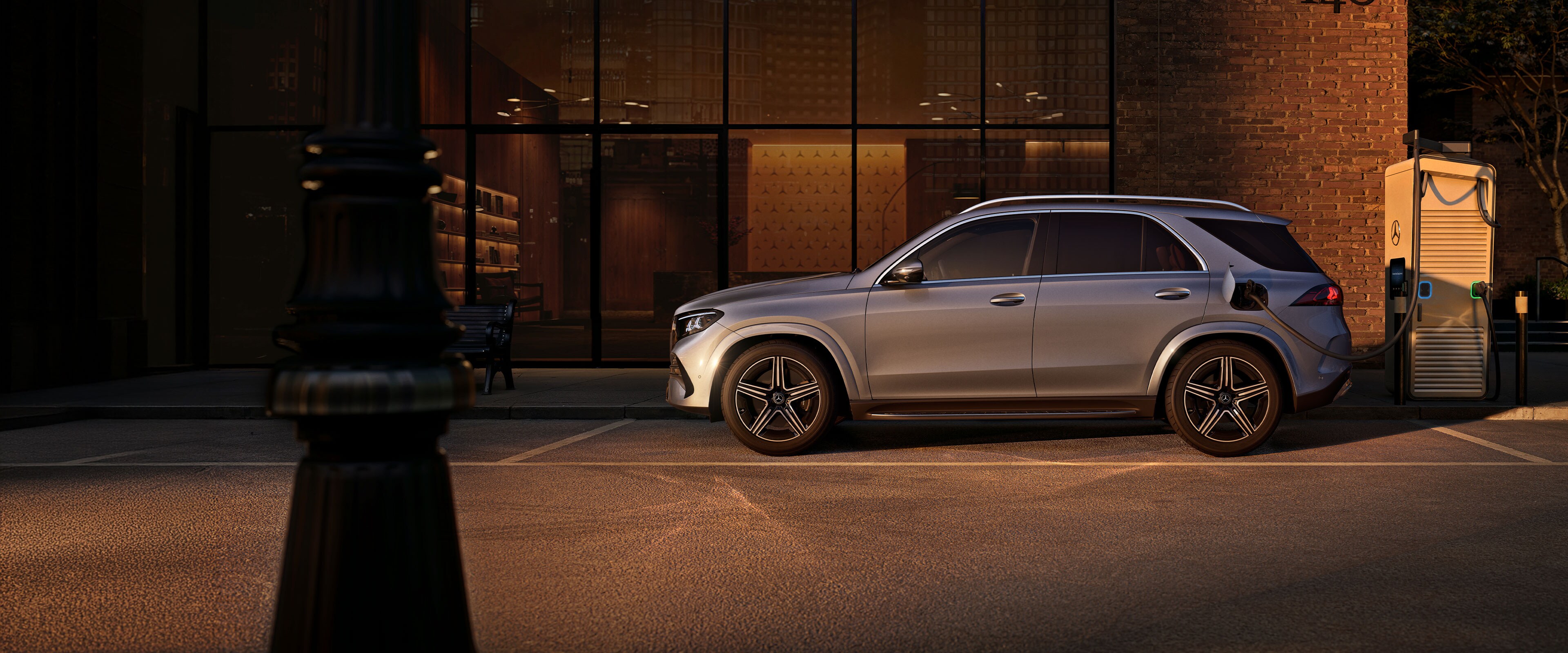 Modelul GLE SUV de la Mercedes-Benz dintr-o perspectivă laterală, în fața unei case mari.
