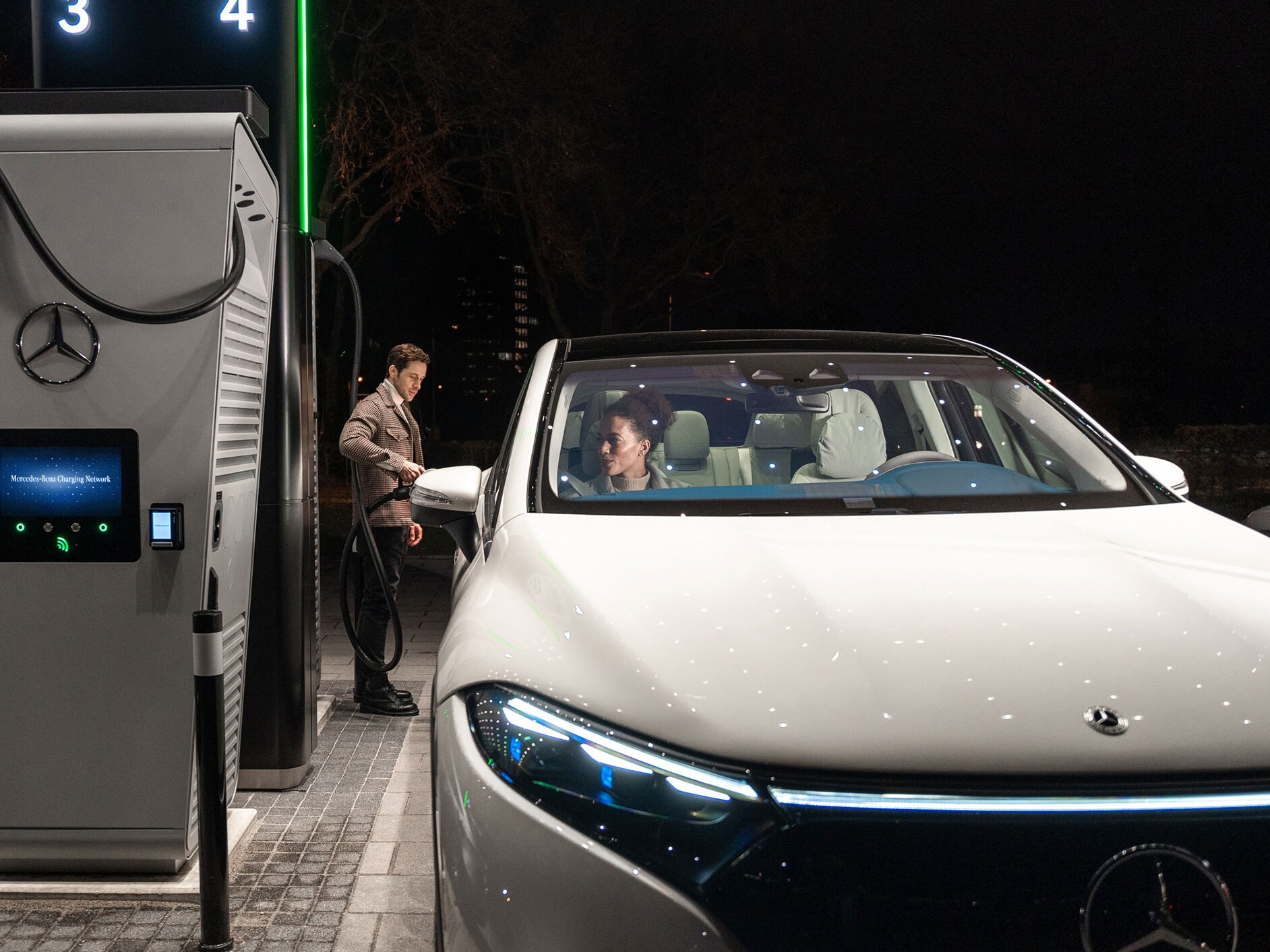 Modelul Mercedes-Benz CLA pe o stradă, conectat la o stație de încărcare.