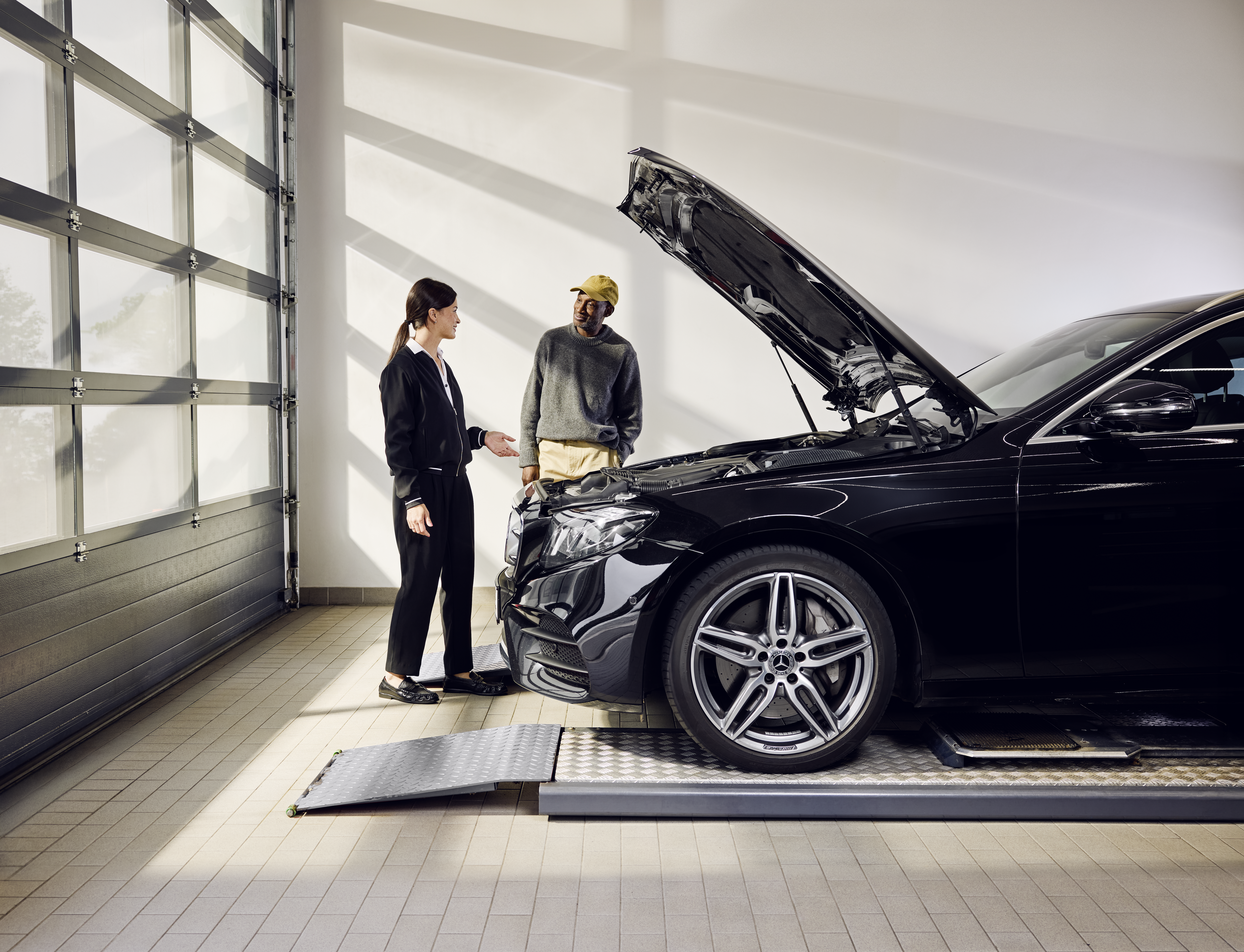 Piese de schimb Mercedes-Benz Un tehnician Mercedes-Benz verifică partea inferioară a unui autovehicul.