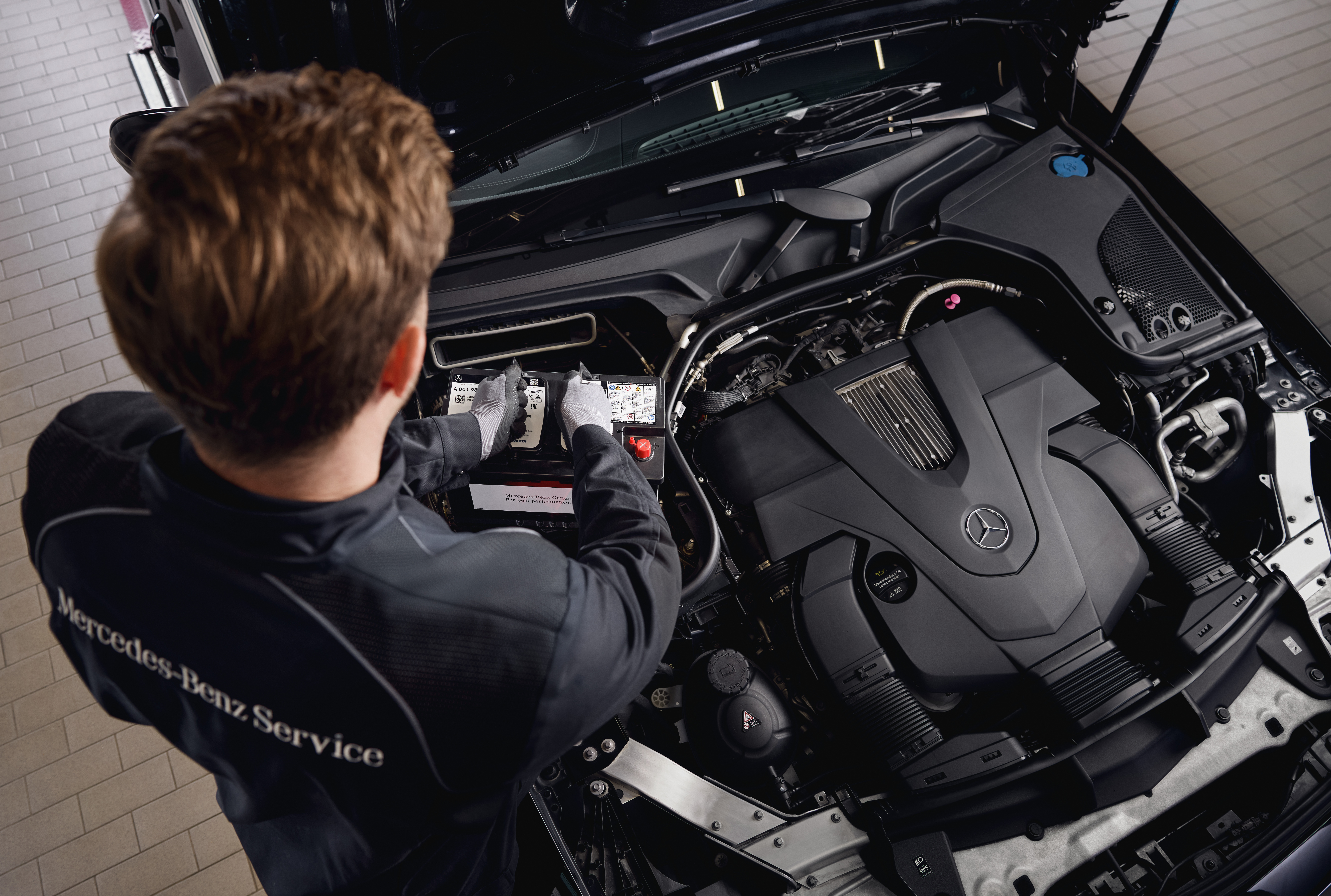 Baterii de pornire de origine Mercedes-Benz Service al motorului într-un atelier, prezentând înlocuirea componentelor cu piese de origine Mercedes-Benz.