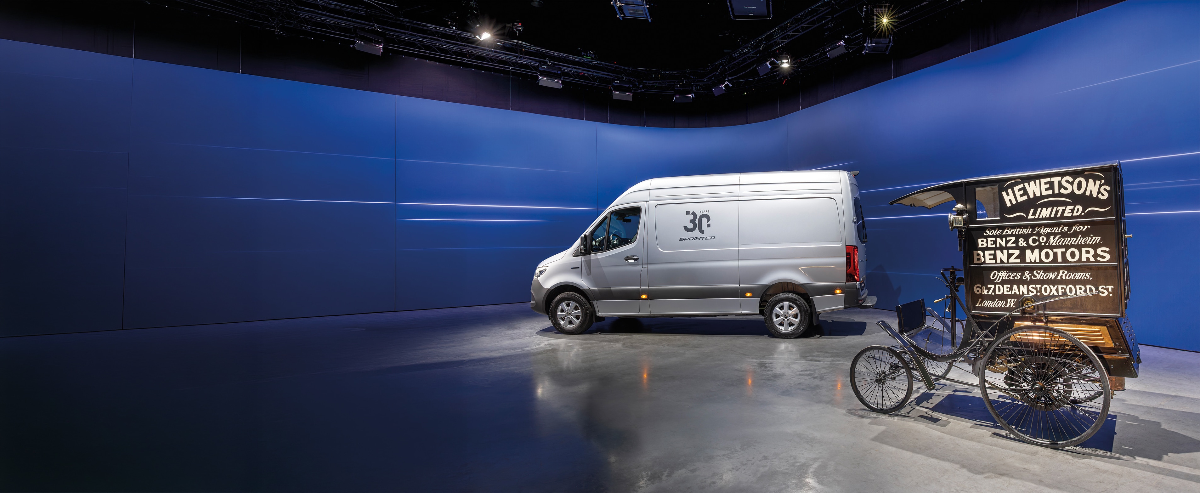 Istorie | Autovehicule utilitare | Mercedes-Benz Mercedes-Benz Sprinter și autovehiculul istoric pentru livrări Benz, prezentate într-un showroom modern