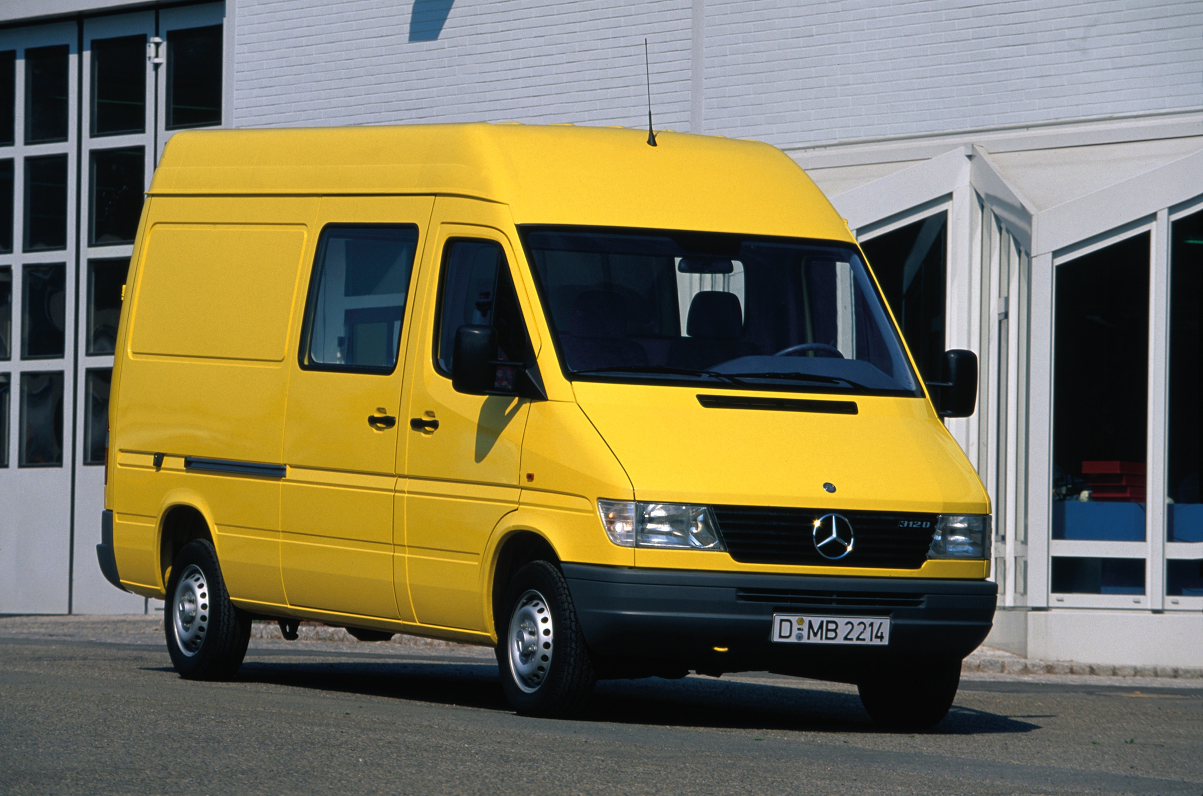Prima generație de Sprintere Mercedes-Benz | Istoria autovehiculelor utilitare | Mercedes-Benz Sprinter din prima generație, parcat în exteriorul unei clădiri industriale