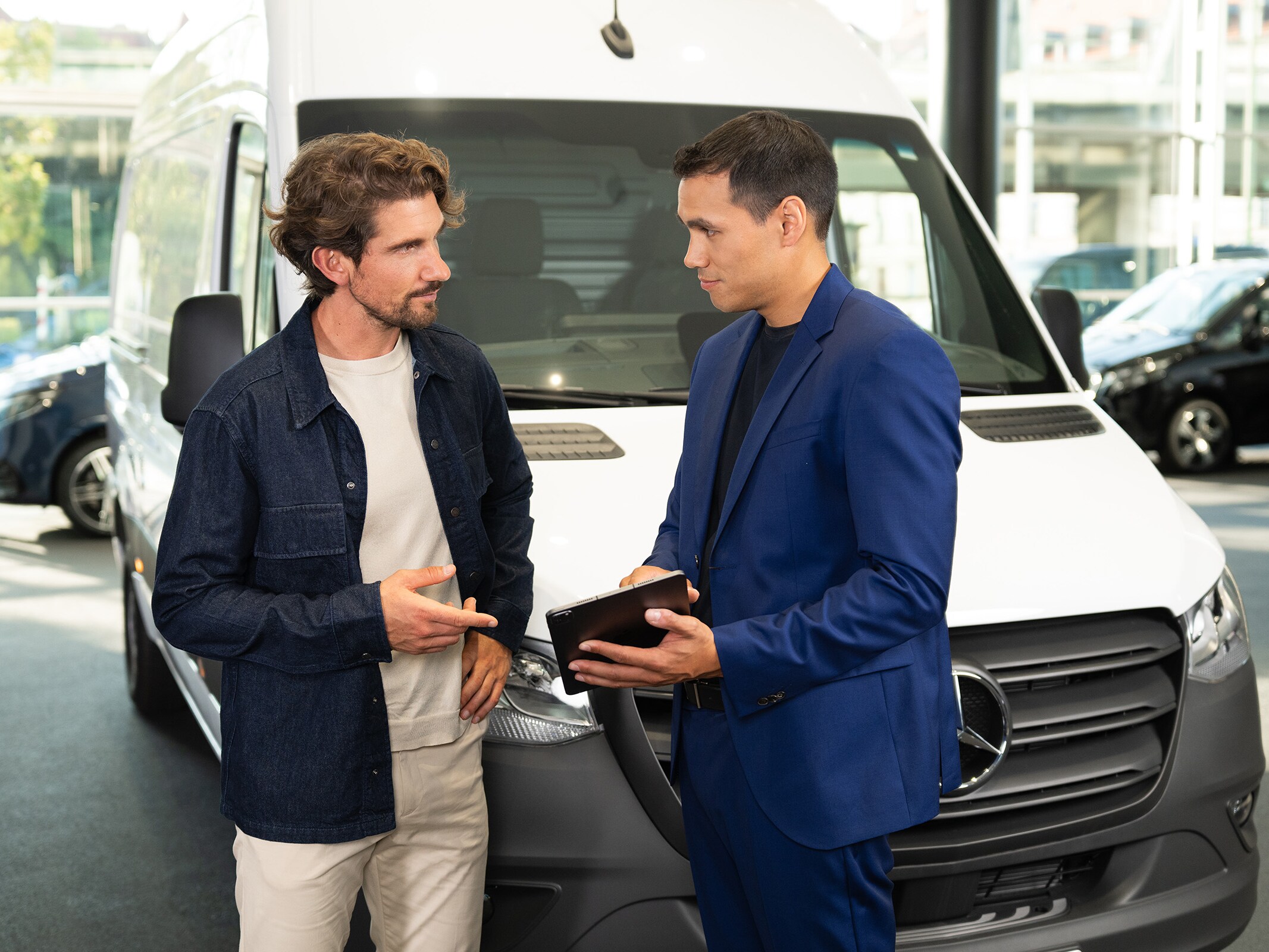 Consultanță pentru autovehicule comerciale Mercedes-Benz într-un showroom, evidențiind serviciul orientat către client.