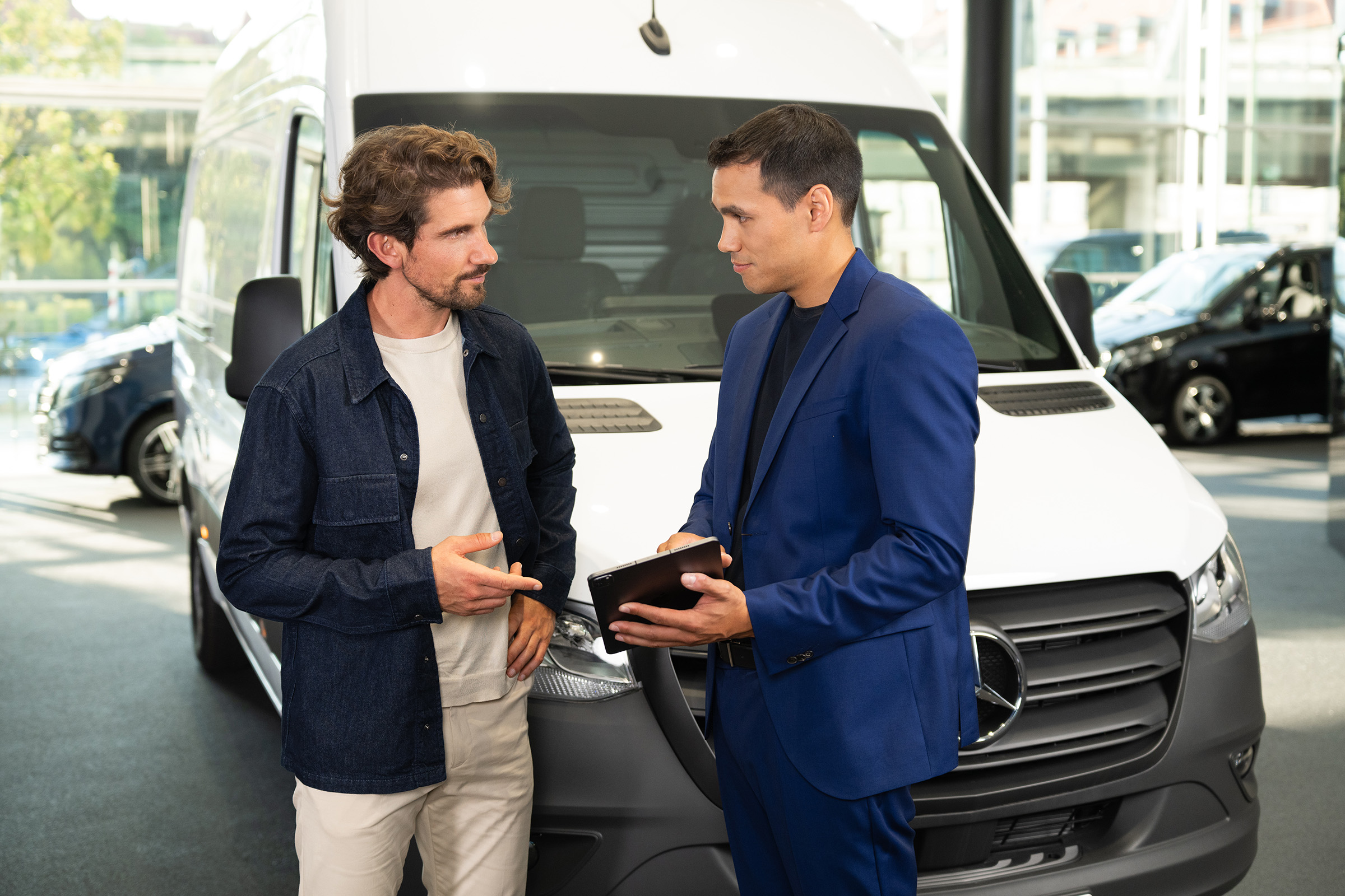 Finanțare și leasing | Modele electrice | Mercedes-Benz Consultanță pentru autovehicule comerciale Mercedes-Benz într-un showroom, evidențiind serviciul orientat către client.