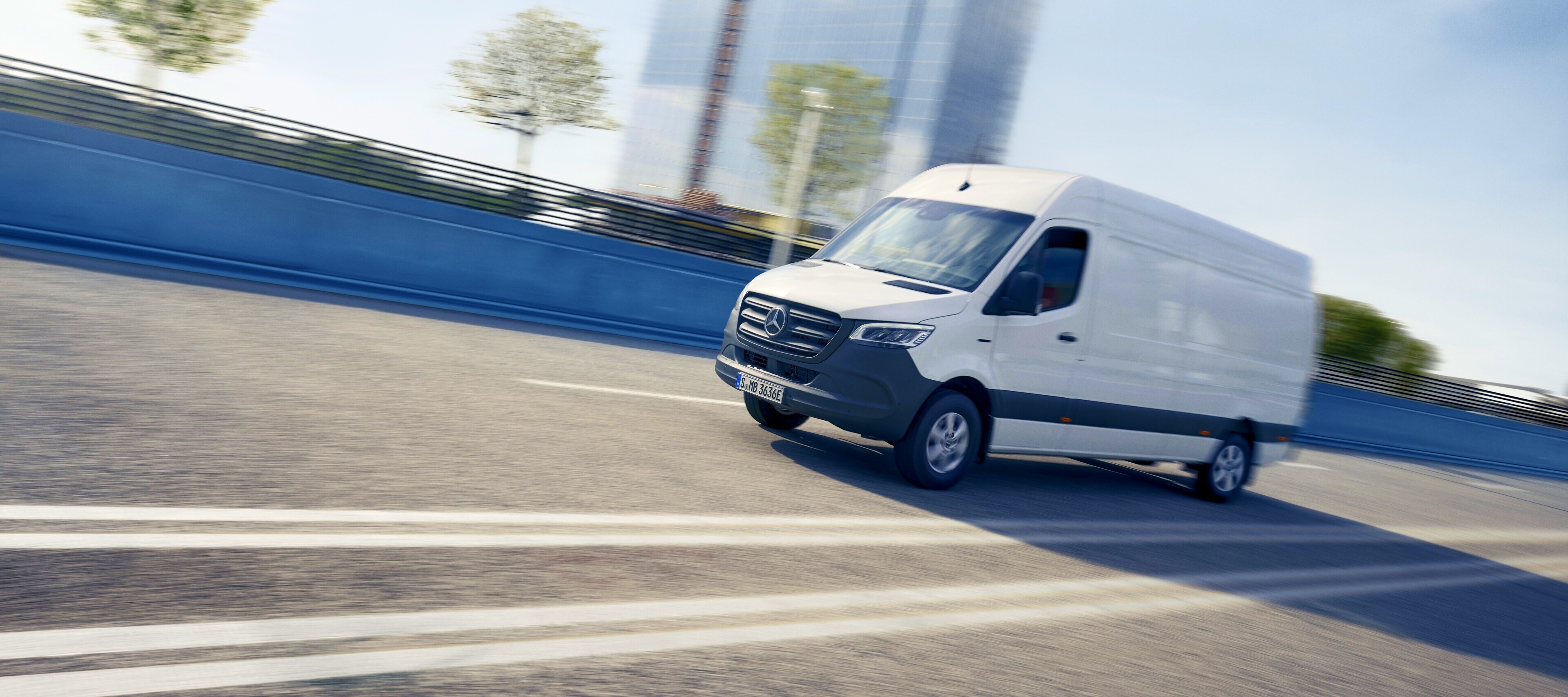 Comparație autovehicule | eSprinter furgonetă cu panou | Mercedes-Benz Modelul Mercedes-Benz eSprinter furgonetă cu panou în centrul orașului.