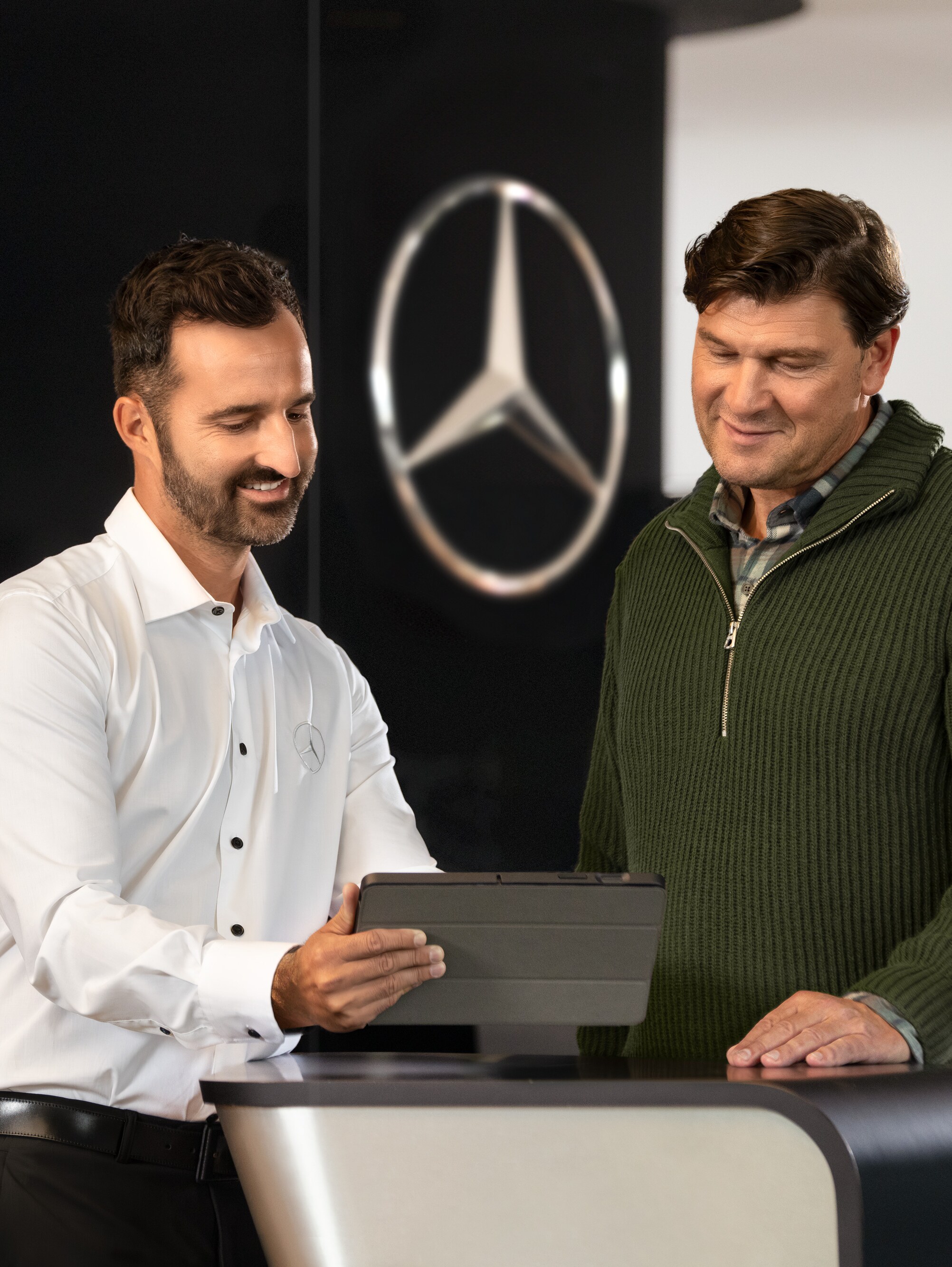 Un angajat Mercedes-Benz oferă asistență la biroul de recepție Mercedes-Benz.
