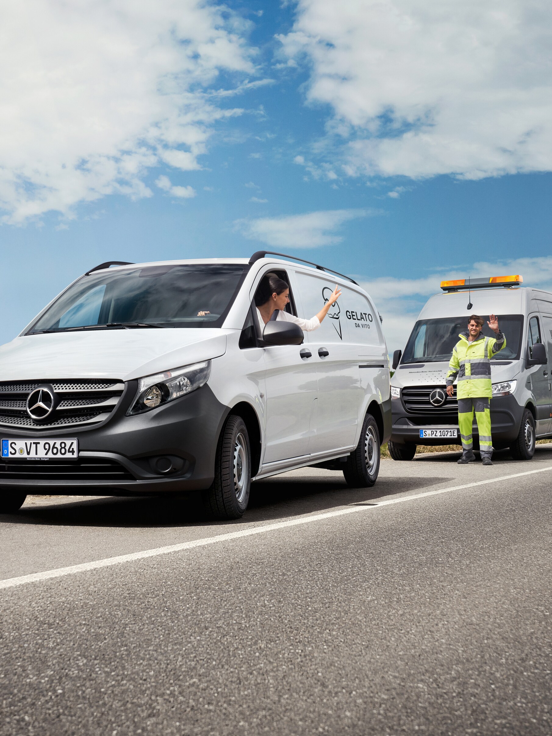O femeie așezată într-un Mercedes-Benz Vito alb face cu mâna unui tehnician de service Mercedes-Benz aflat pe cealaltă parte a drumului.
