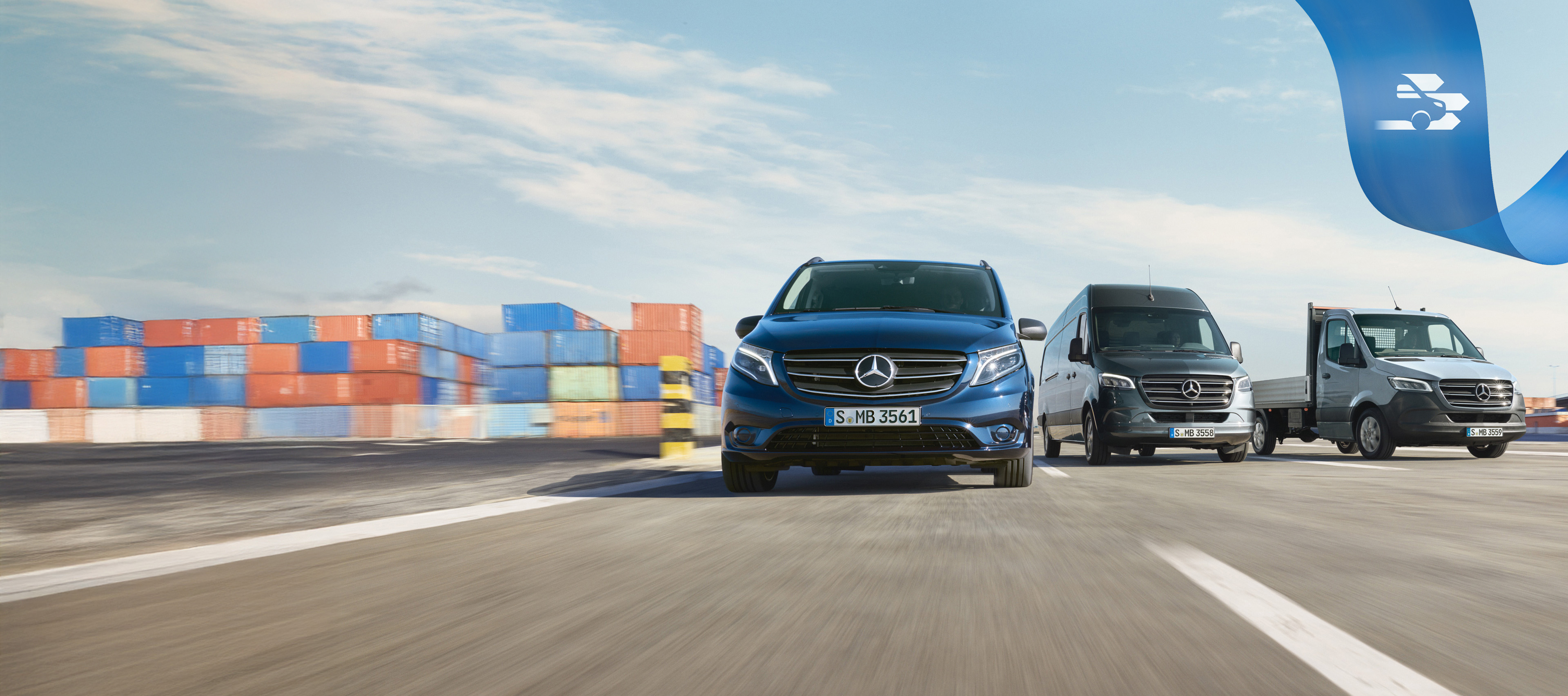 Mercedes Benz | Comoditate MobiloVan O serie de autovehicule comerciale Mercedes-Benz pe drum cu containere transcontinentale în fundal.