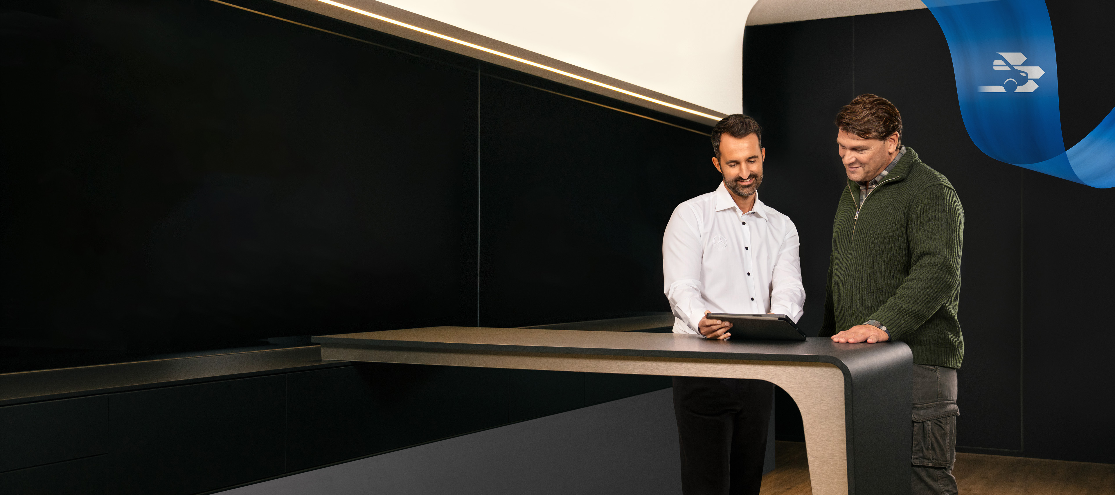 Mercedes-Benz | Comoditate | Partener de service Doi bărbați stau în birourile unui partener de service Mercedes-Benz Service, discutând.
