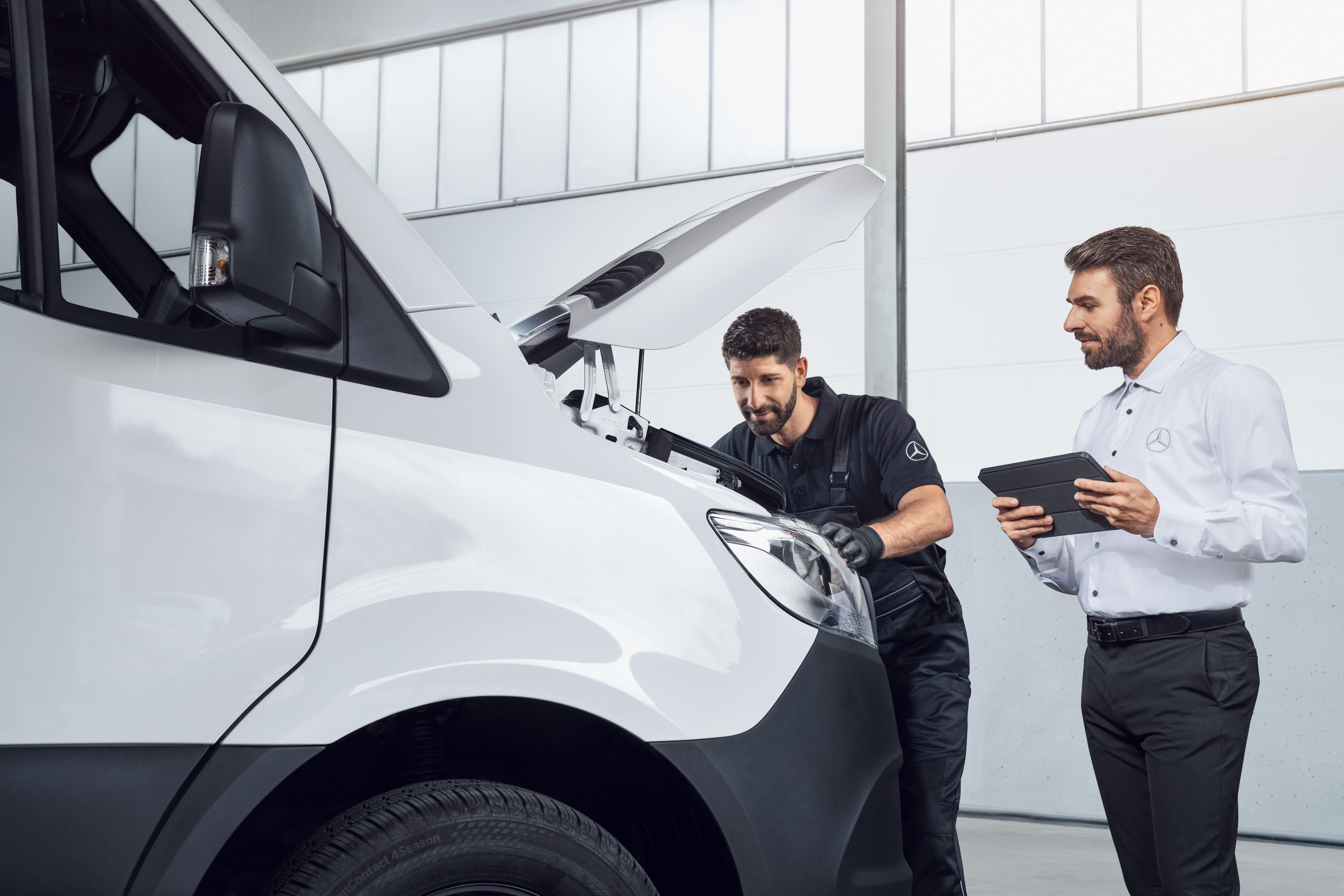 Mercedes-Benz | Piese de origine de calitate pentru autovehicule comerciale Doi bărbați testează un model Mercedes Sprinter cu tableta și capota motorului deschisă, subiect: Piese de schimb de origineMercedes-Benz Sprinter.