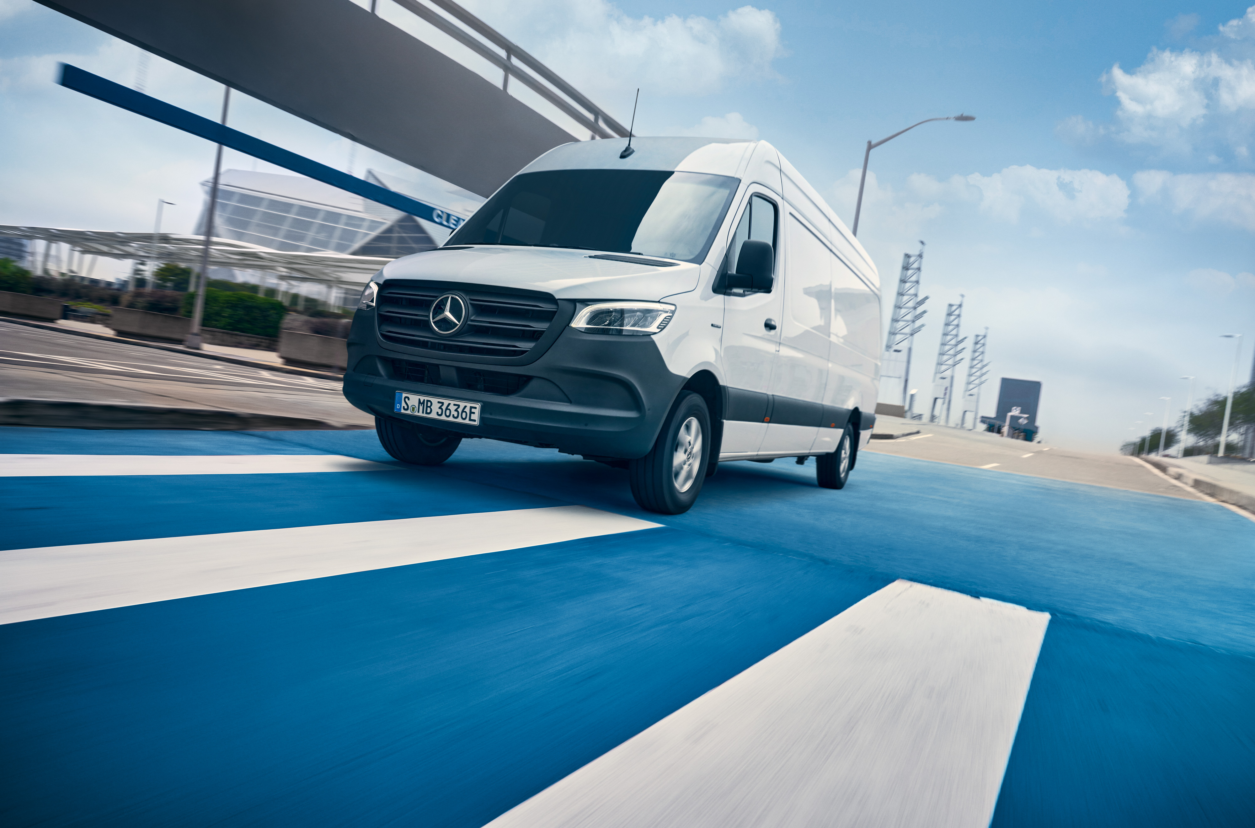 Mercedes-Benz | ServiceCare pentru furgonete | Pachet de revizie O furgonetă Mercedes-Benz Sprinter albă circulă pe un drum dintr-un oraș.